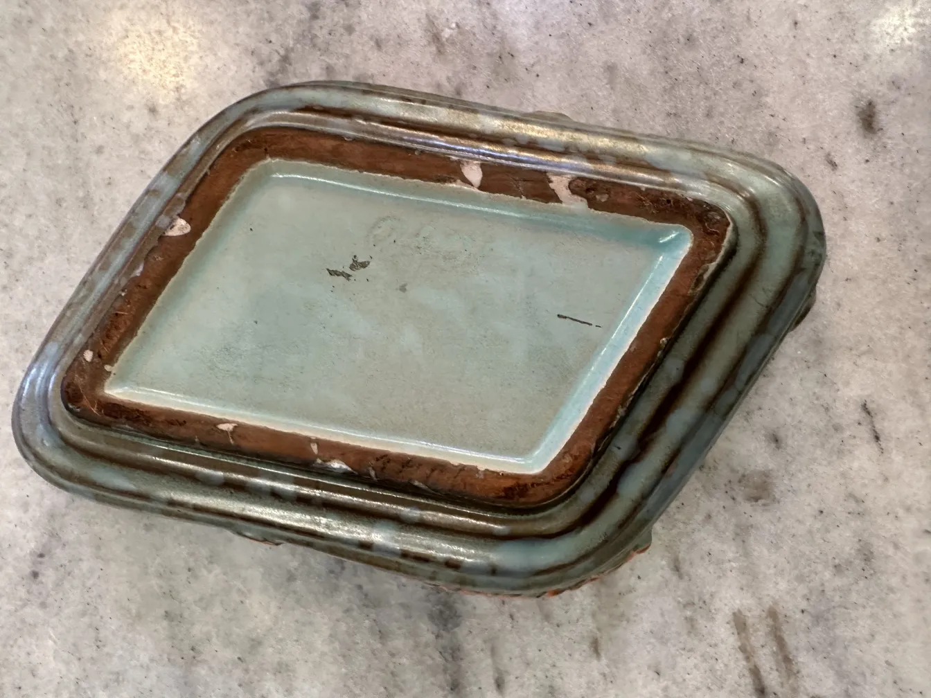 Ceramica antigua decorada con hojas en tonos naranja y marrón