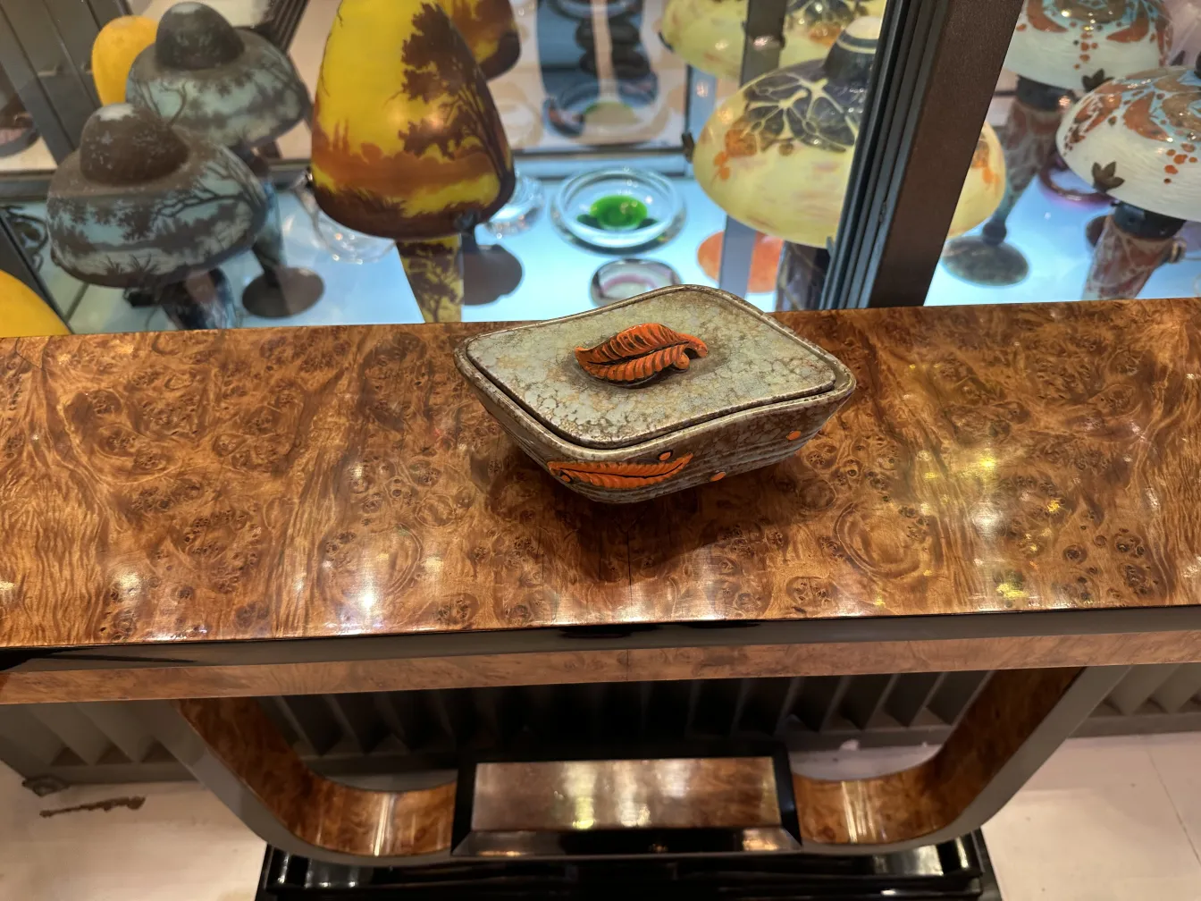 Ceramica antigua decorada con hojas en tonos naranja y marrón