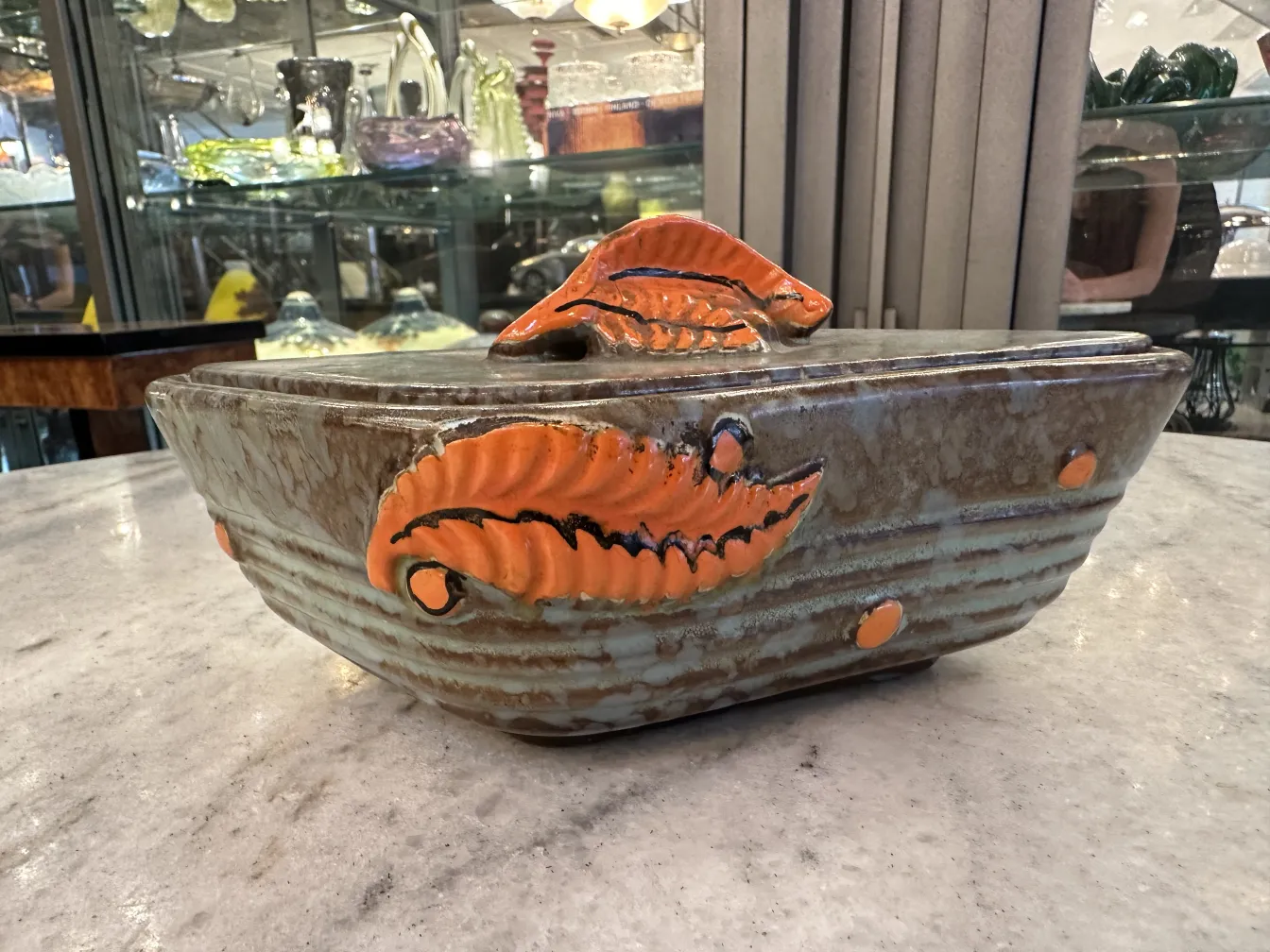 Ceramica antigua decorada con hojas en tonos naranja y marrón