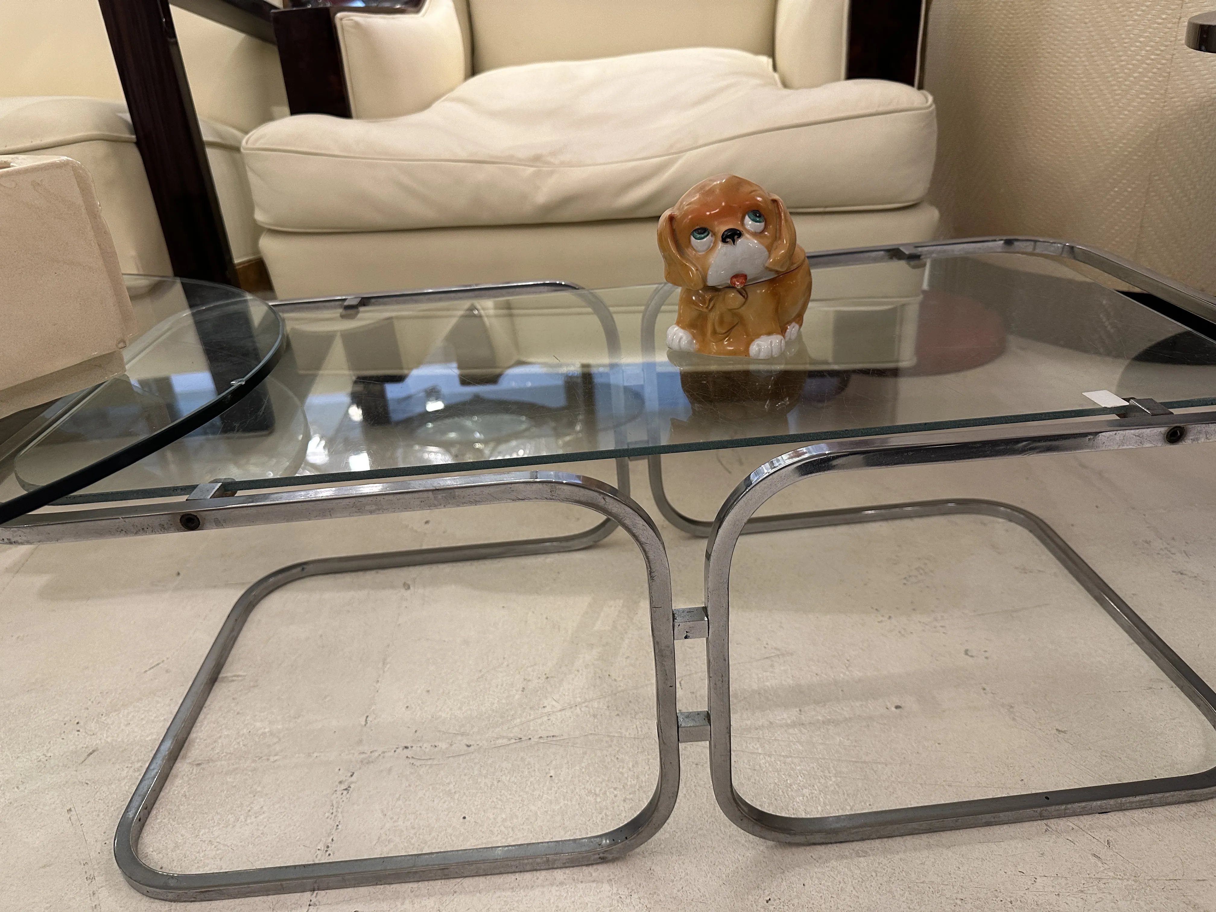 Figurita antigua de cerámica con forma de perro, sentada sobre la mesa.