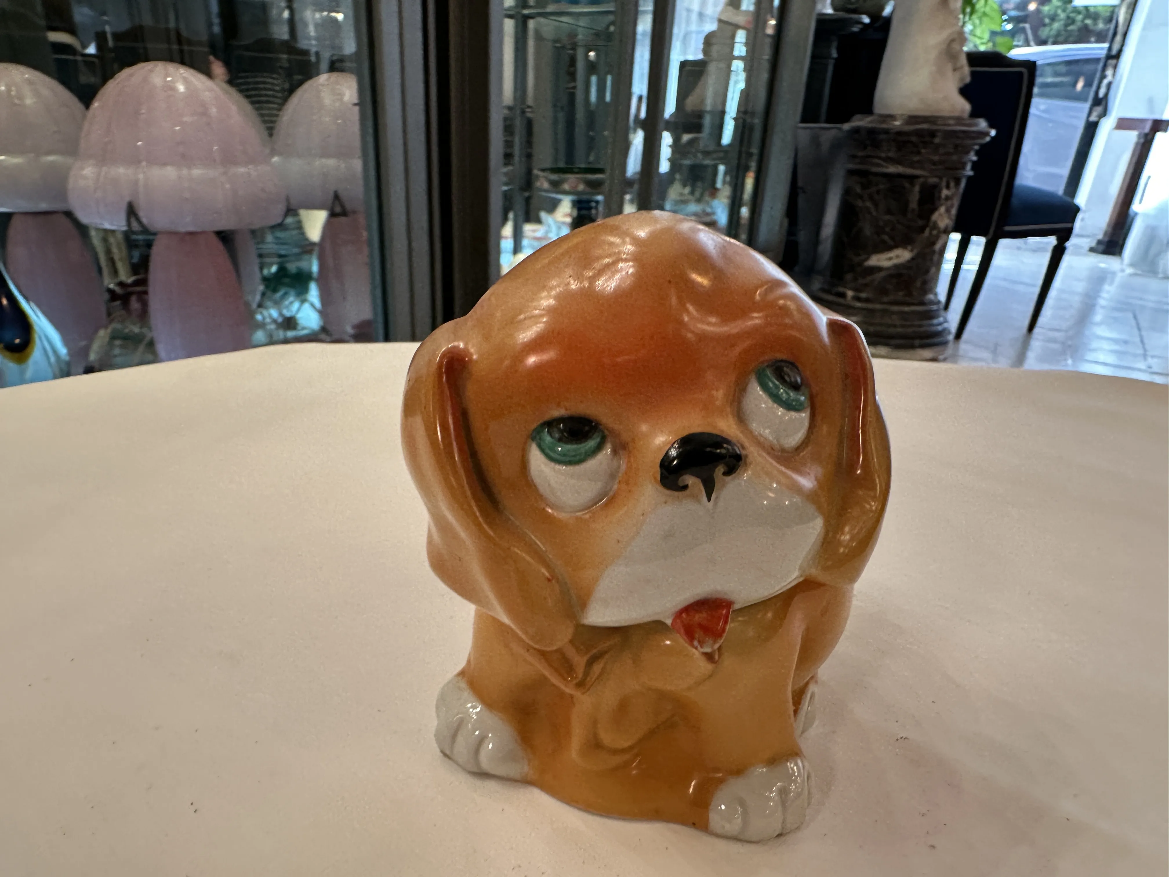 Scultura di cane in ceramica antica con dettagli colorati in un ambiente elegante.