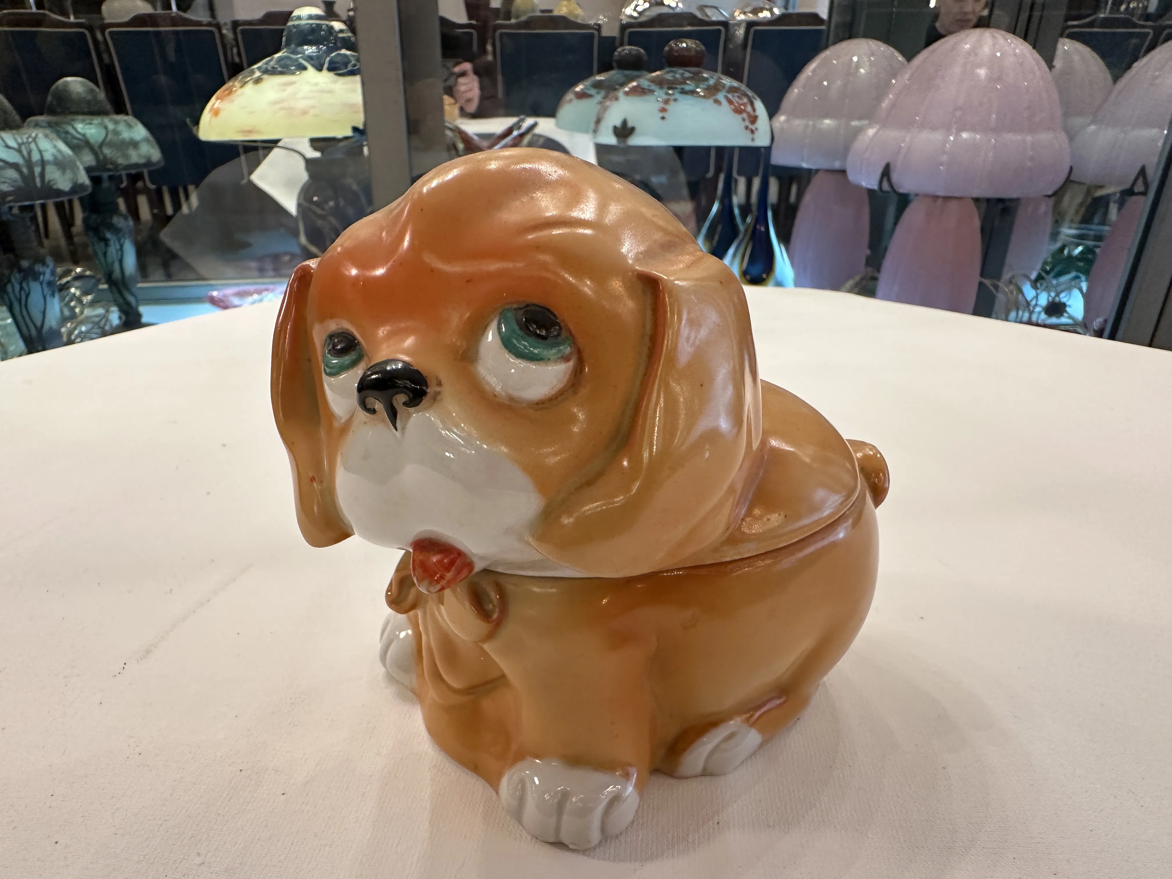 Figura antigua de cerámica en forma de perro marrón claro.