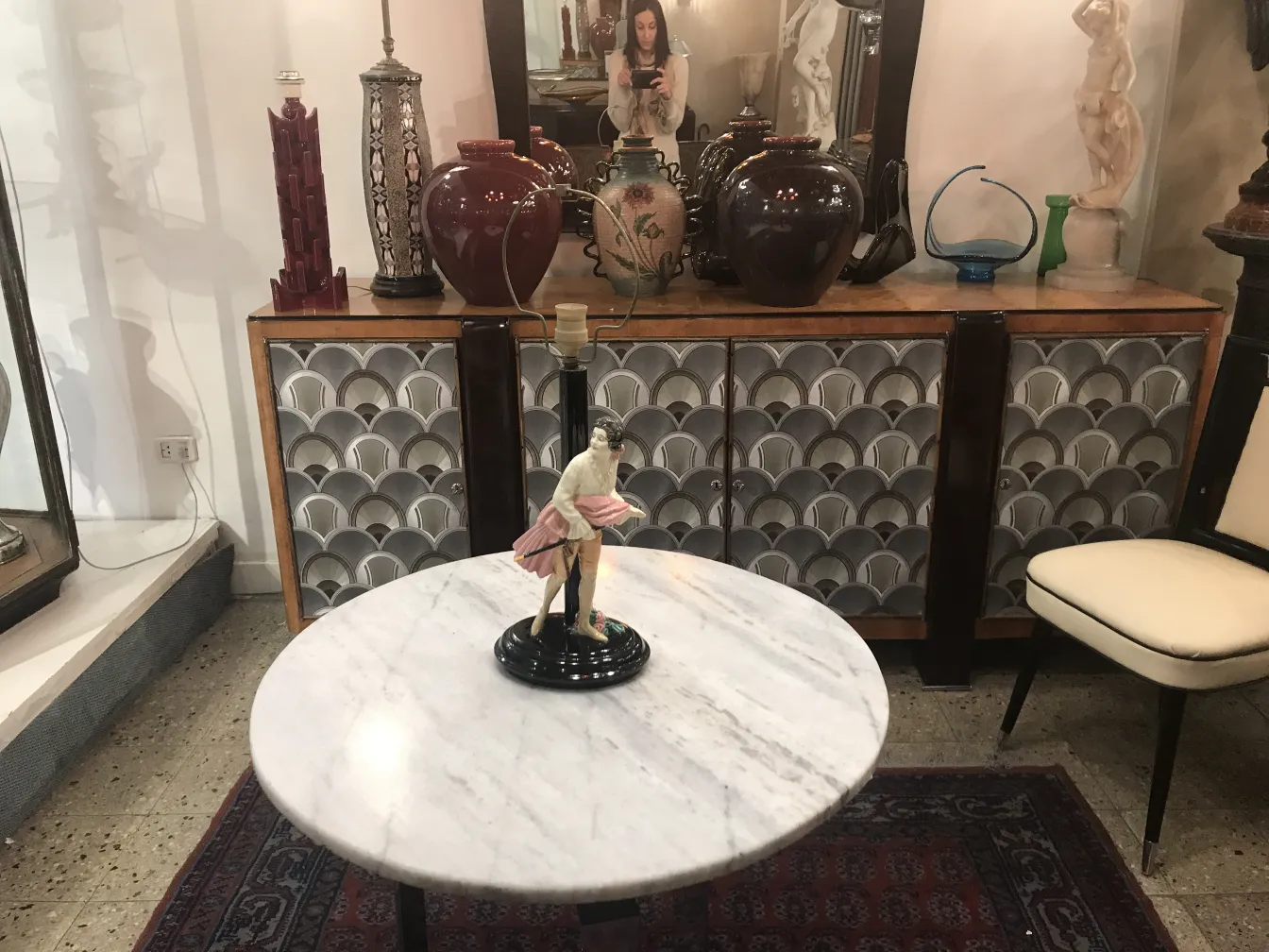 Antike Tischlampe mit dekorativer Figur und elegantem Hintergrund.