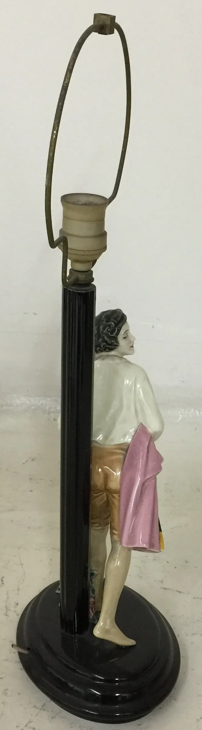 antiga luminária de mesa com figura de cerâmica na base, ambiente neutro