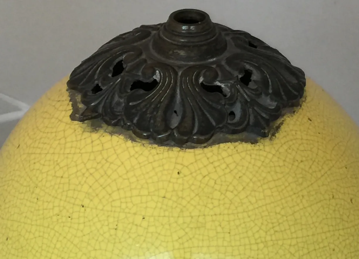 Lampada da tavolo antica gialla con design art deco e dettagli decorativi sopra.