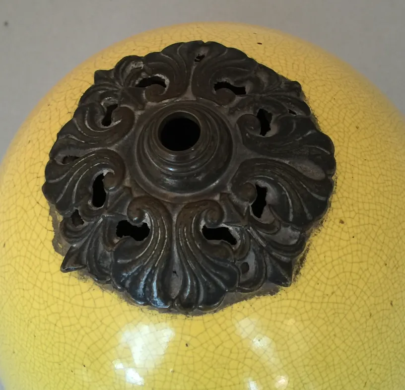 detalhe de uma luminária de mesa antiga Art Deco amarela com design ornamental