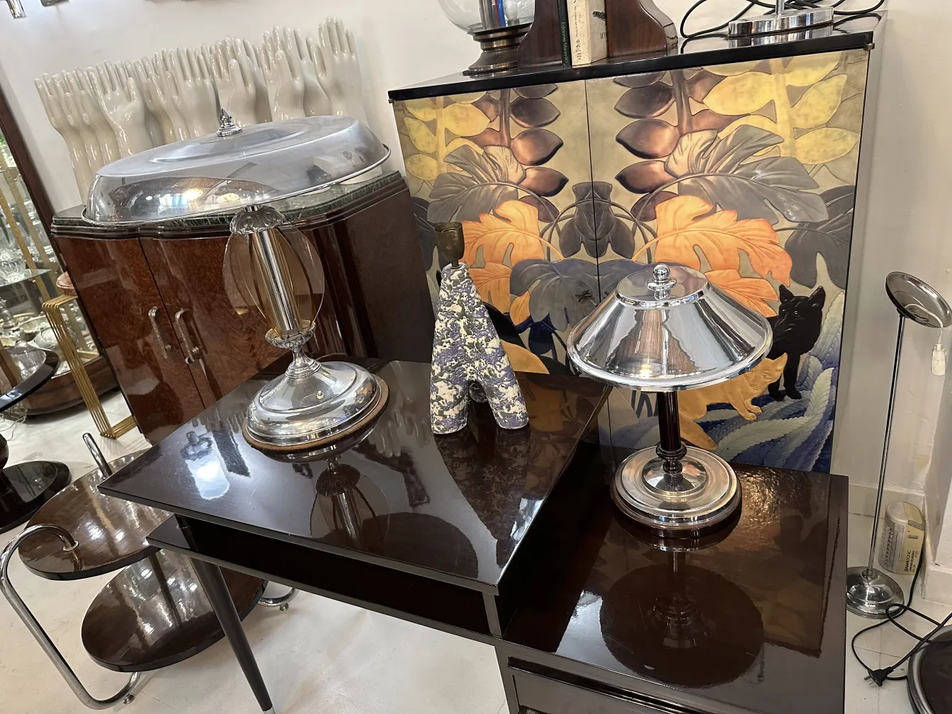 luminária de mesa antiga com base brilhante e cúpula cônica, cercada por um ambiente elegante
