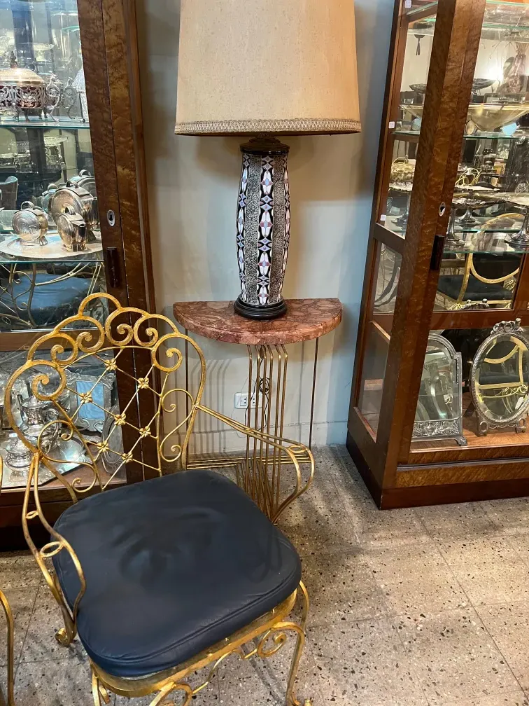 lampe de bureau ancienne avec abat-jour beige et base décorée, dans un environnement d'antiquités