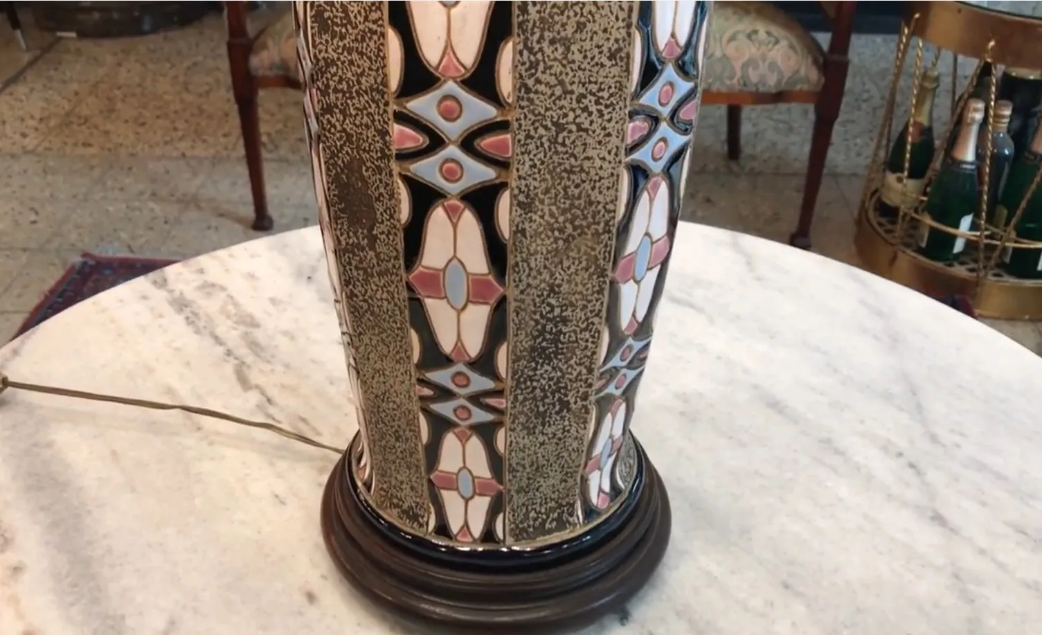 Lámpara de mesa antigua con diseño colorido y detalles únicos en un ambiente clásico