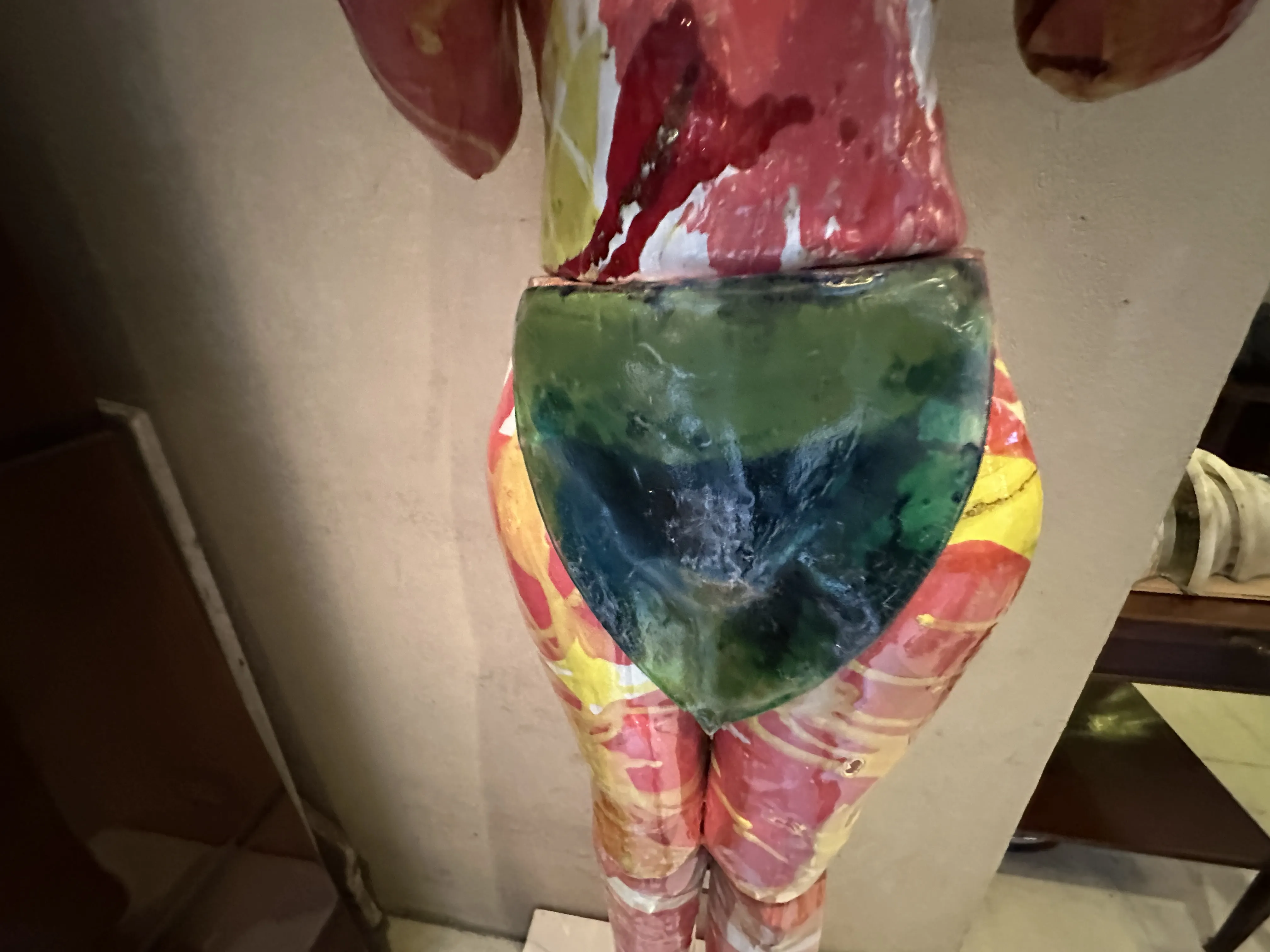 Escultura de cerámica antigua con colores vibrantes.