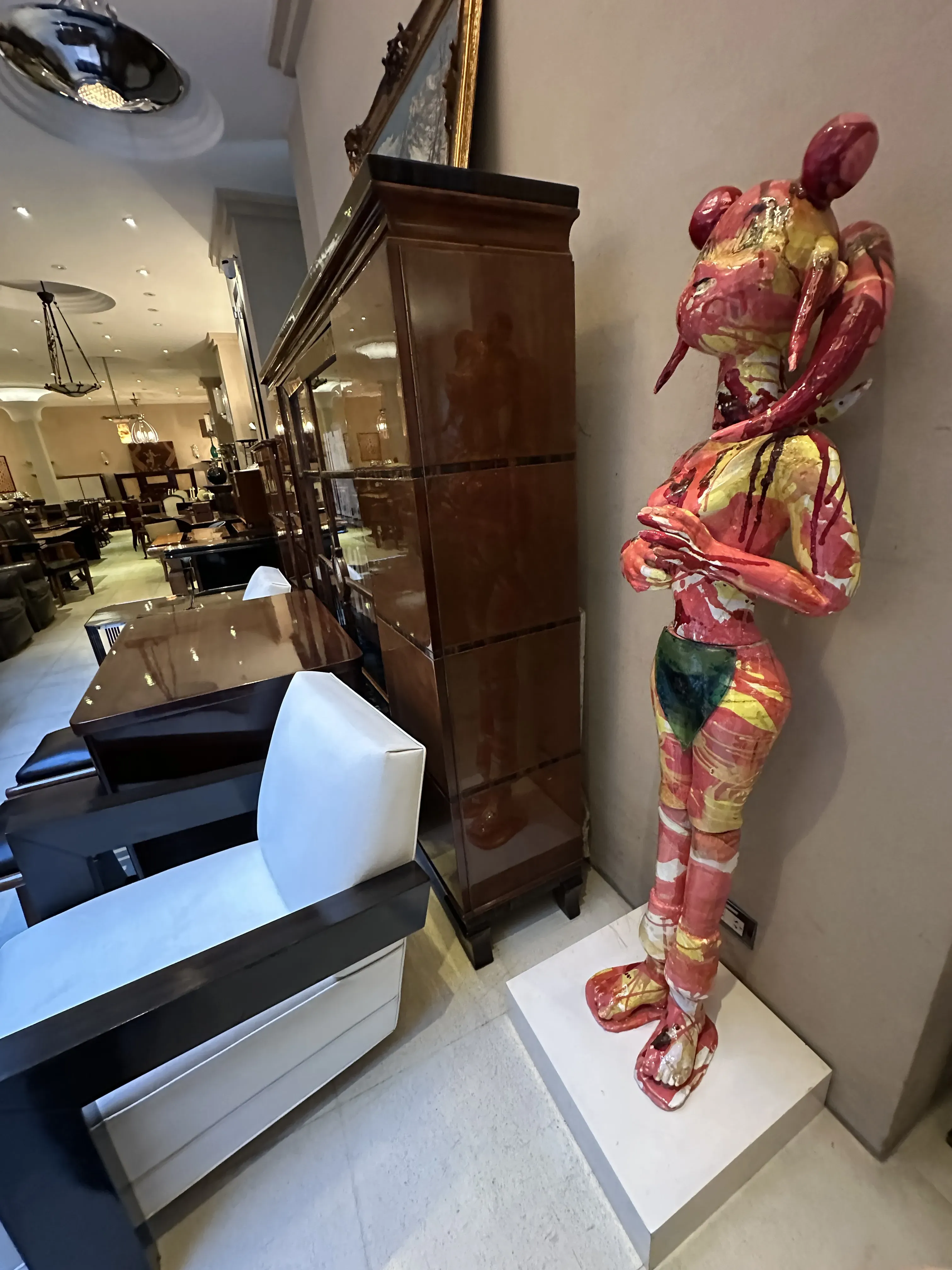 Escultura antiga de cerâmica com cores vibrantes em um ambiente elegante.