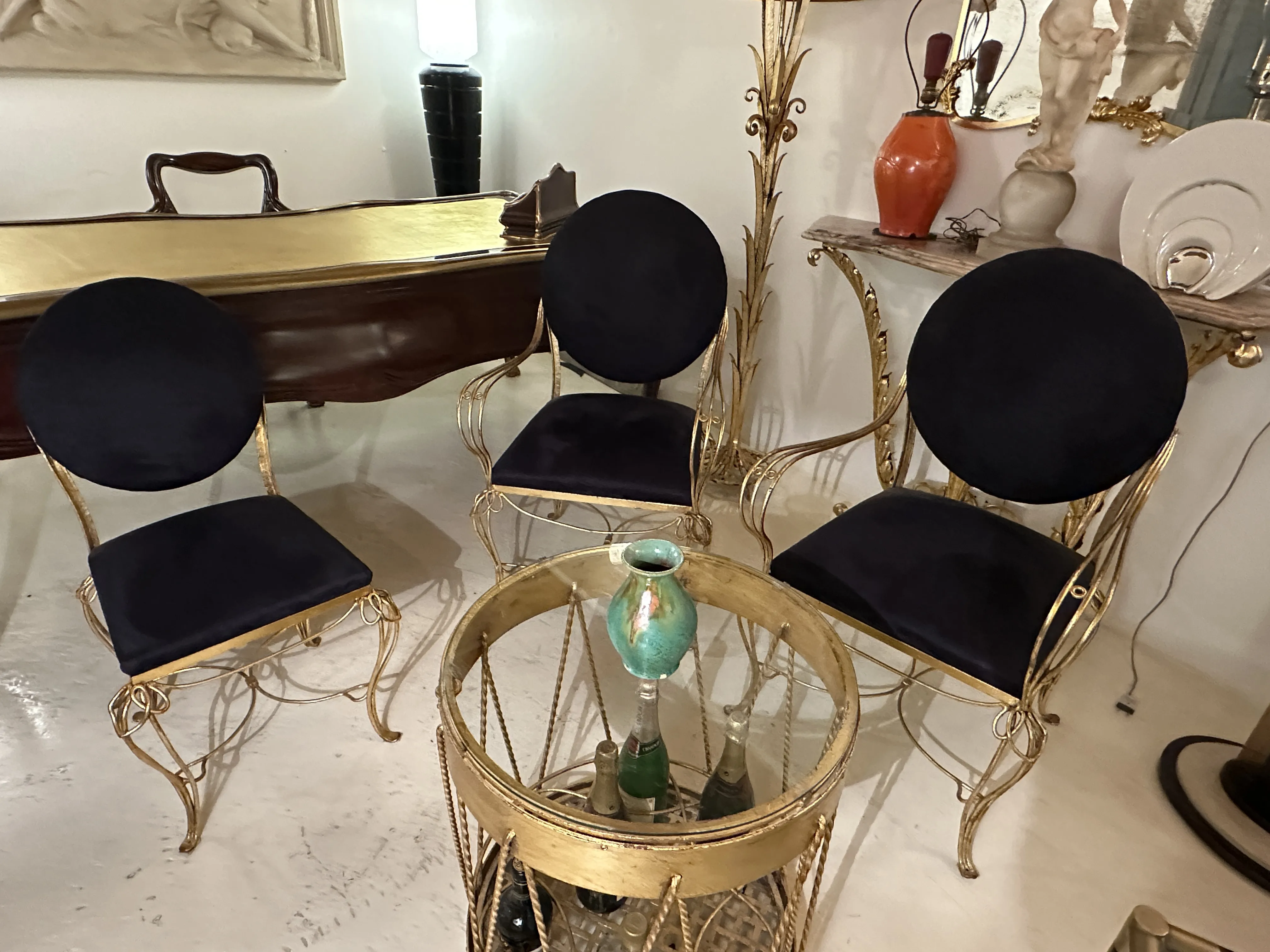 ثلاث كراسي ذهبية مع وسائد مخملية داكنة، طاولة سيراميك