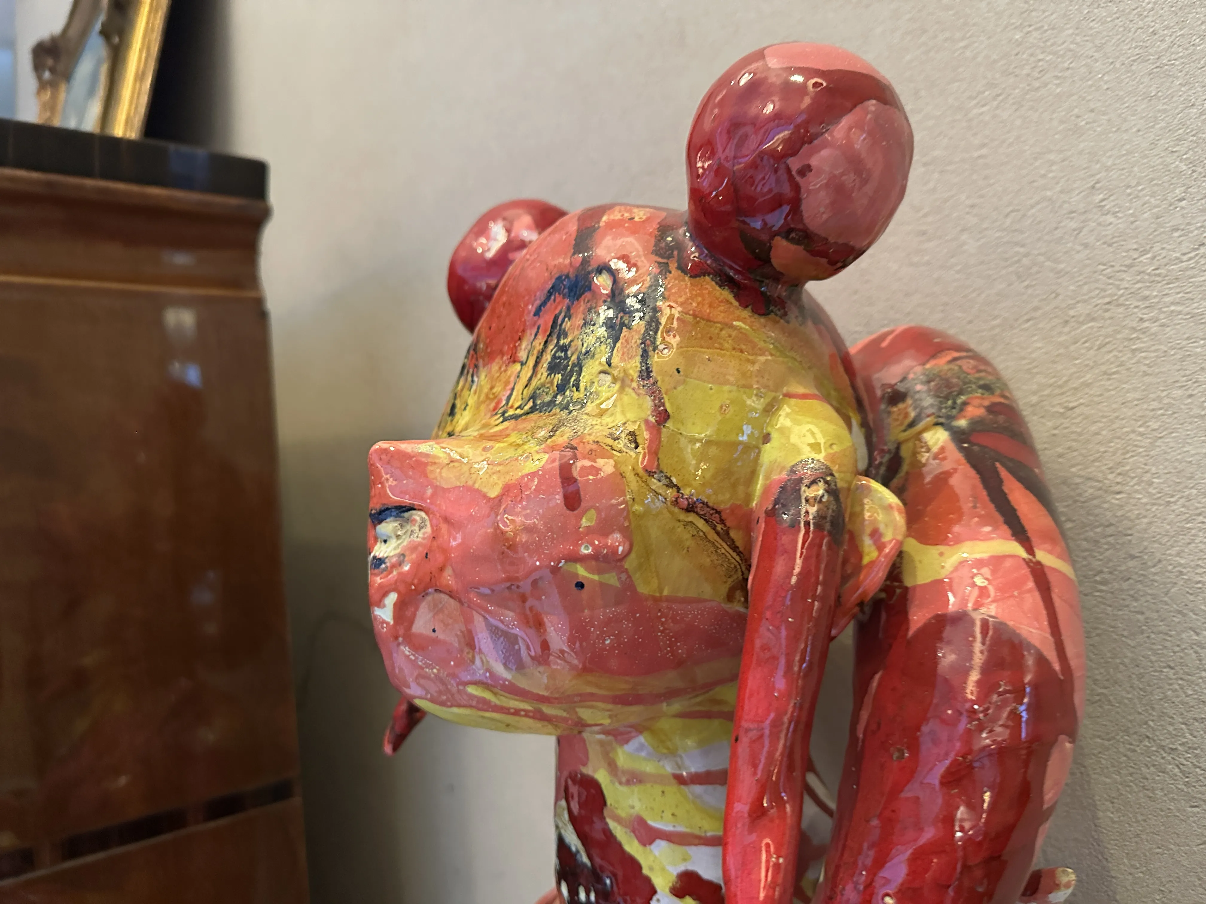 Ceramica antica con un design vibrante in rosso, giallo e nero, che abbellisce un ambiente elegante.