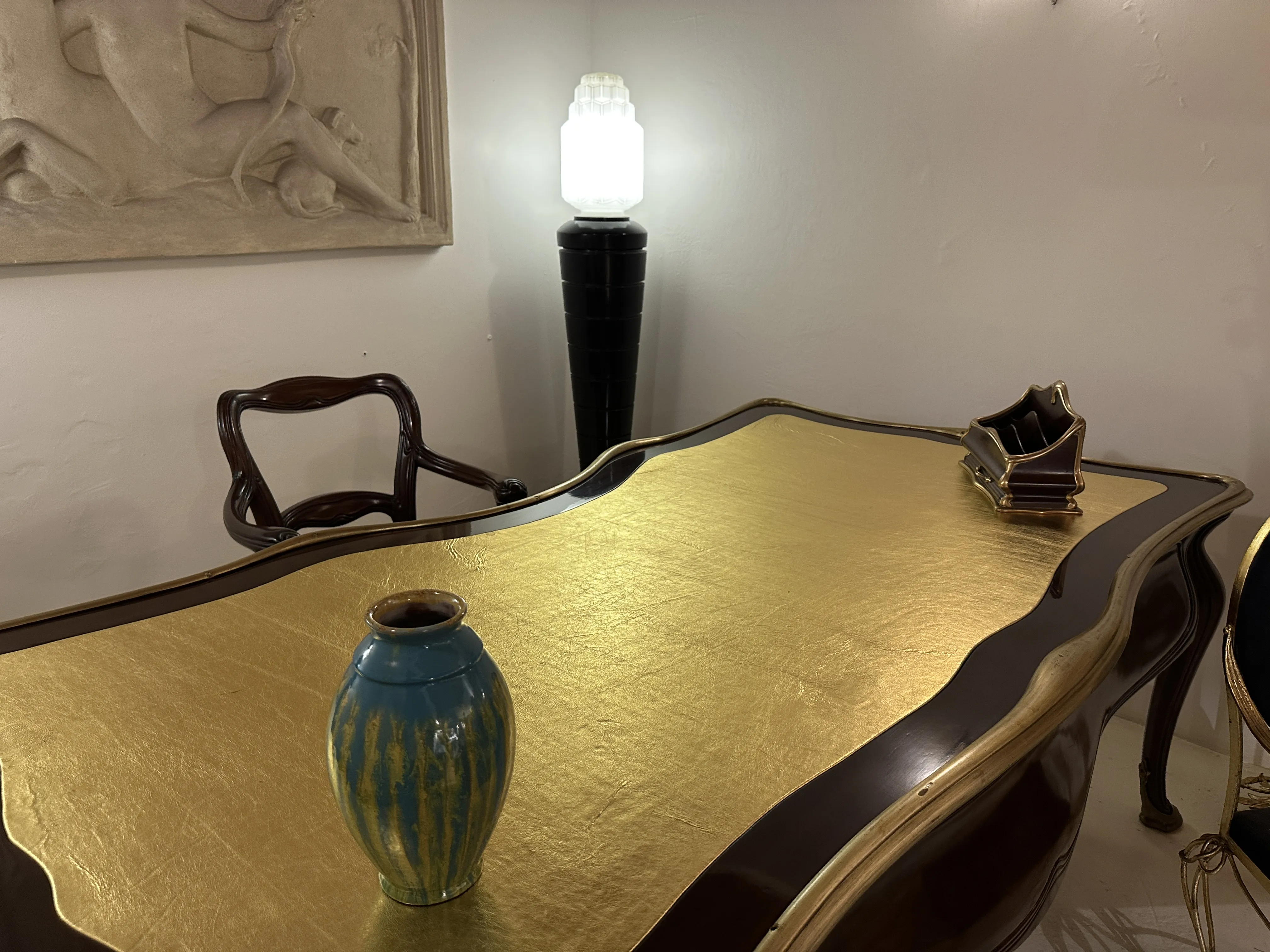 Jarros de cerâmica antiga com linhas decorativas em azul e verde, sobre uma mesa dourada.