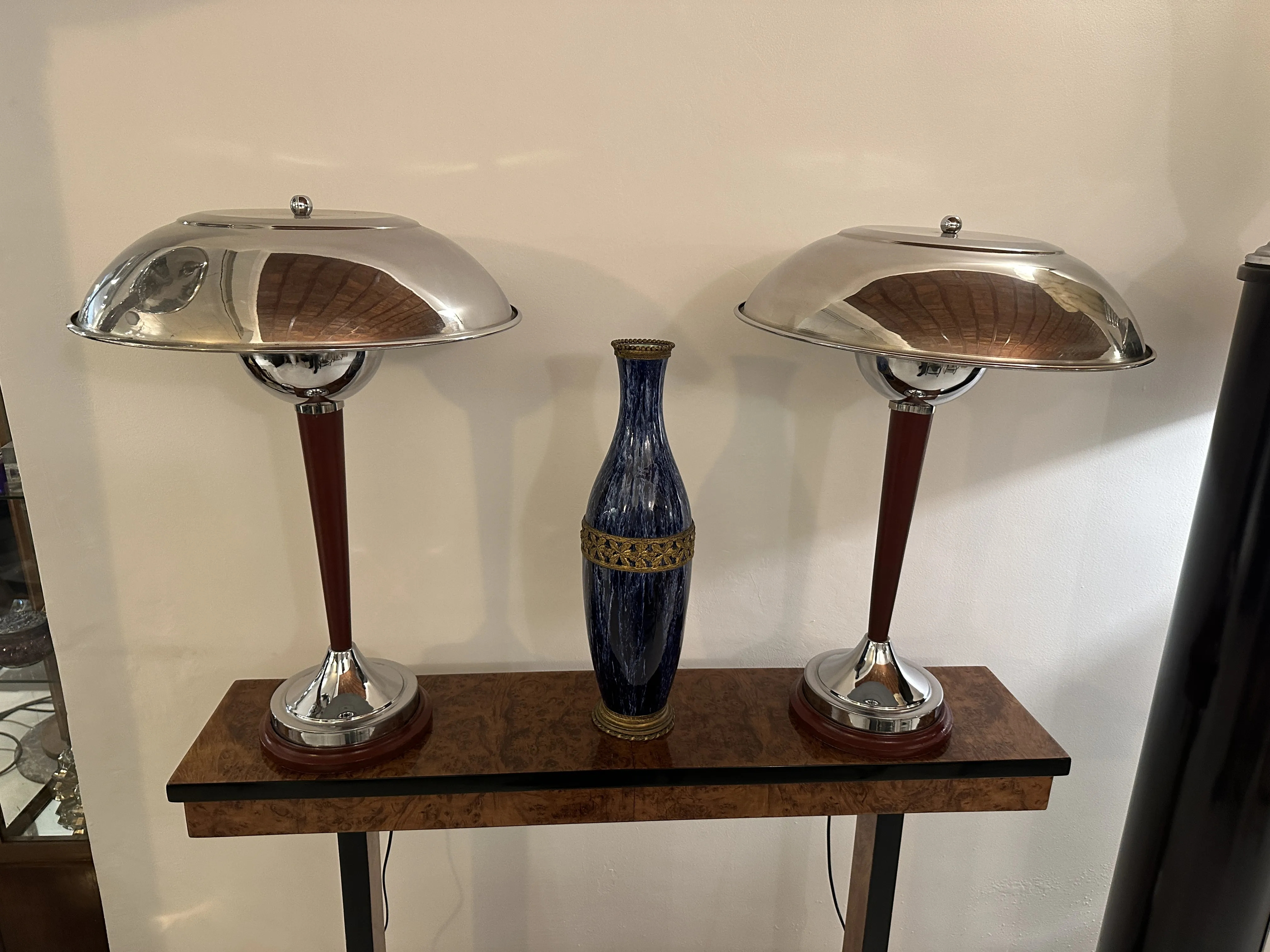 vaso in ceramica antica con design blu e dorato, lampade moderne sullo sfondo
