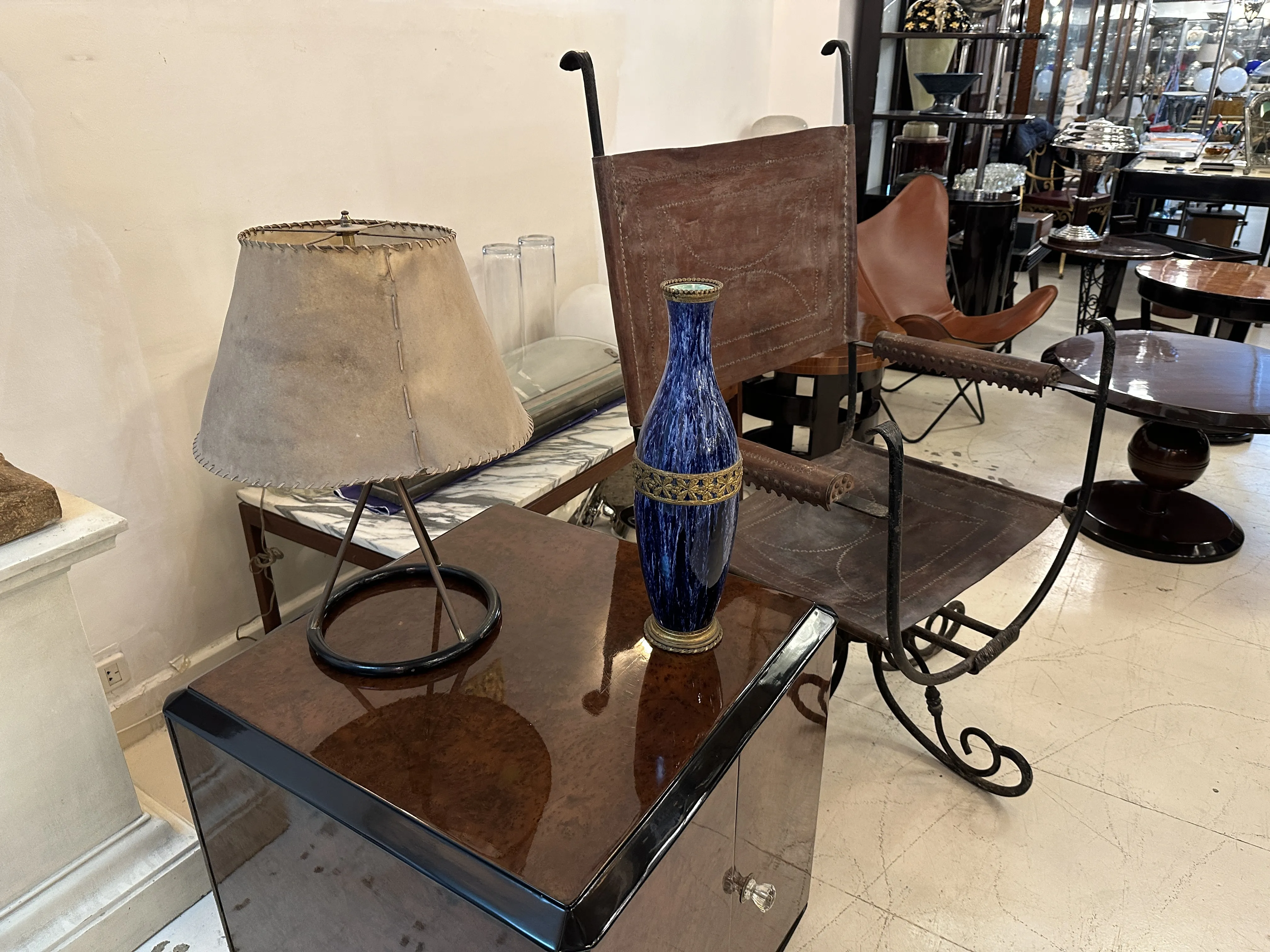 Vaso de cerâmica antiga sobre mesa com lâmpada e cadeira