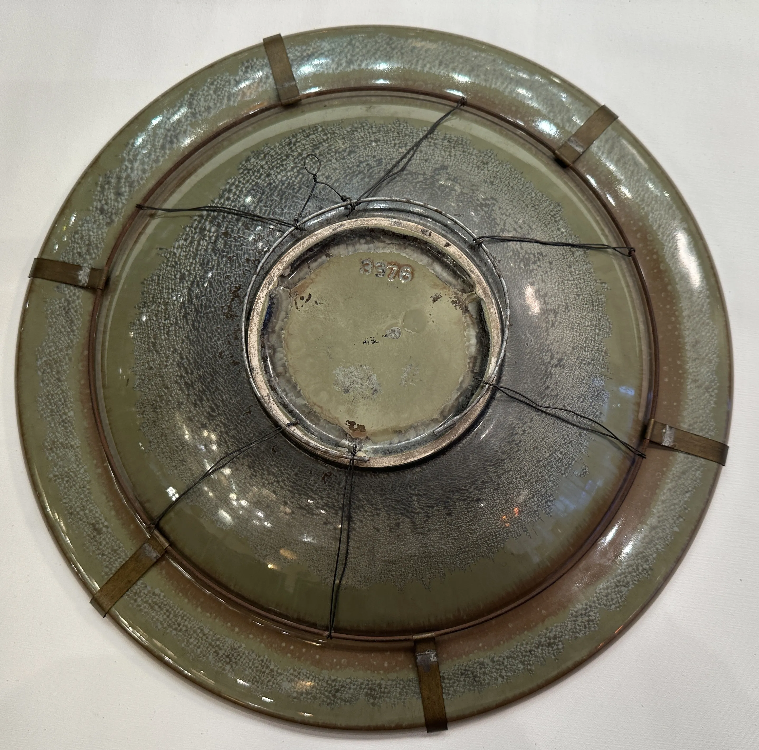 Piatto ceramico antico con colori tenui e decorazioni sottili.