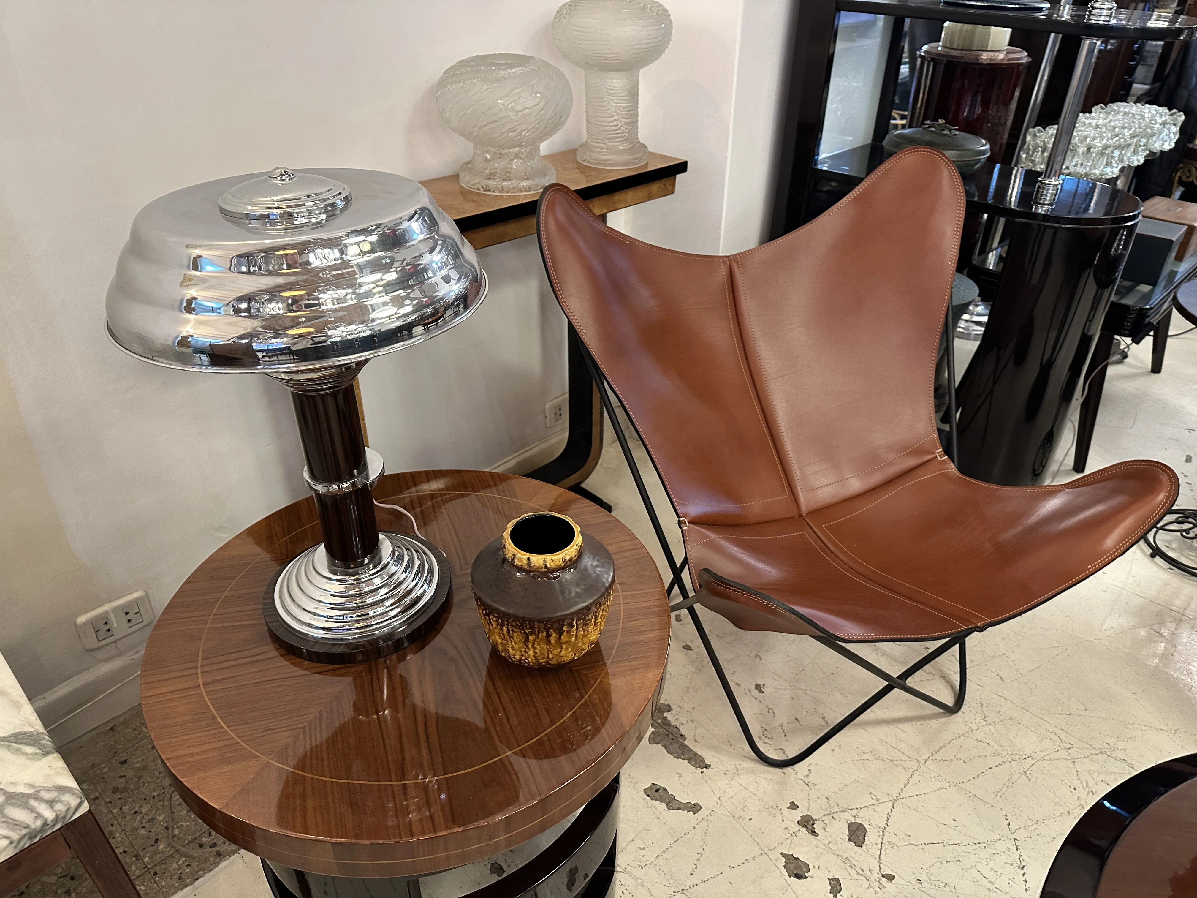 エレガントな設定の中にある輝く古い陶器、傍にランプと椅子があります。