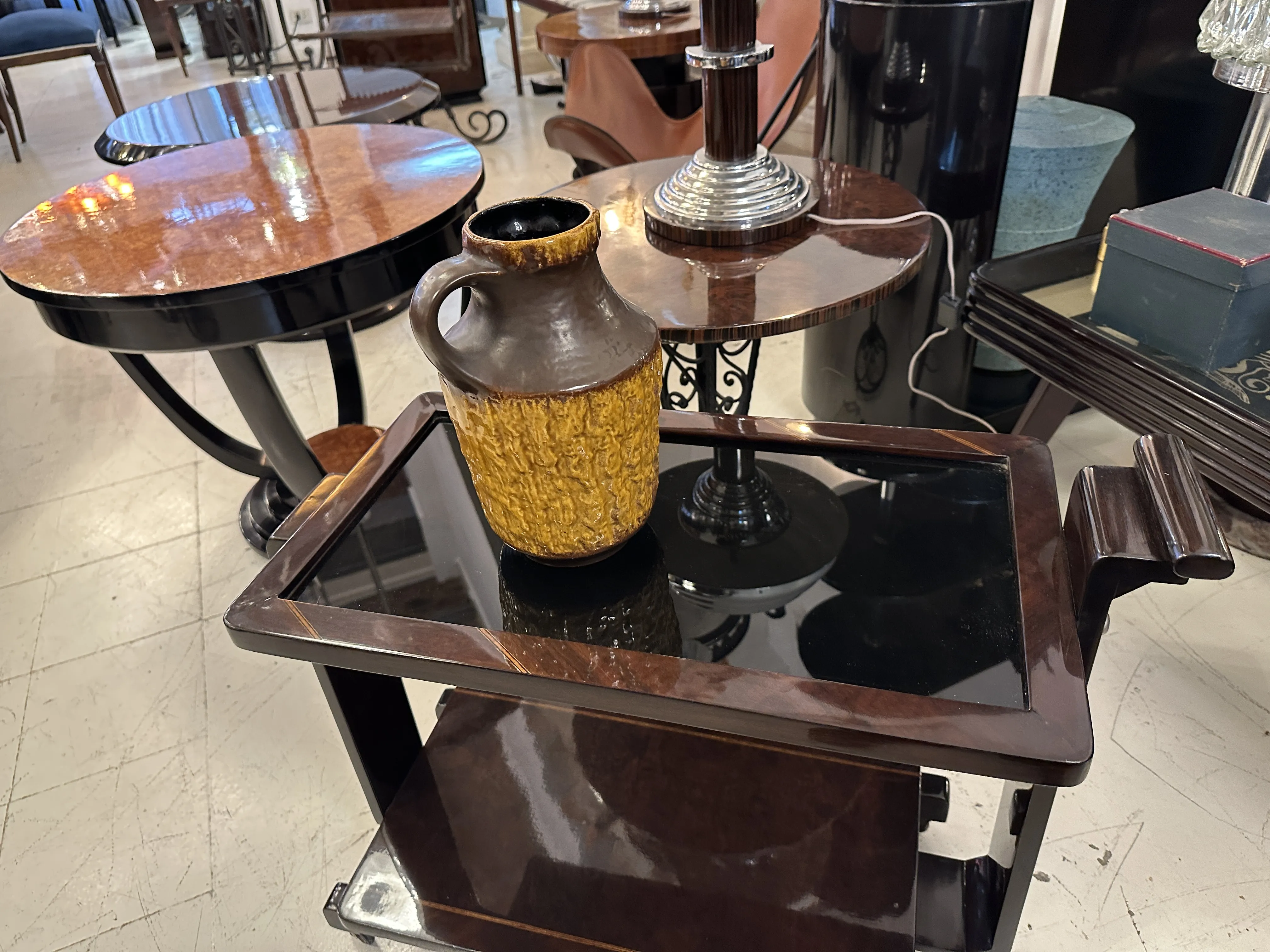 Ancienne céramique en forme de jarre jaune avec décoration unique sur une table en bois sombre.