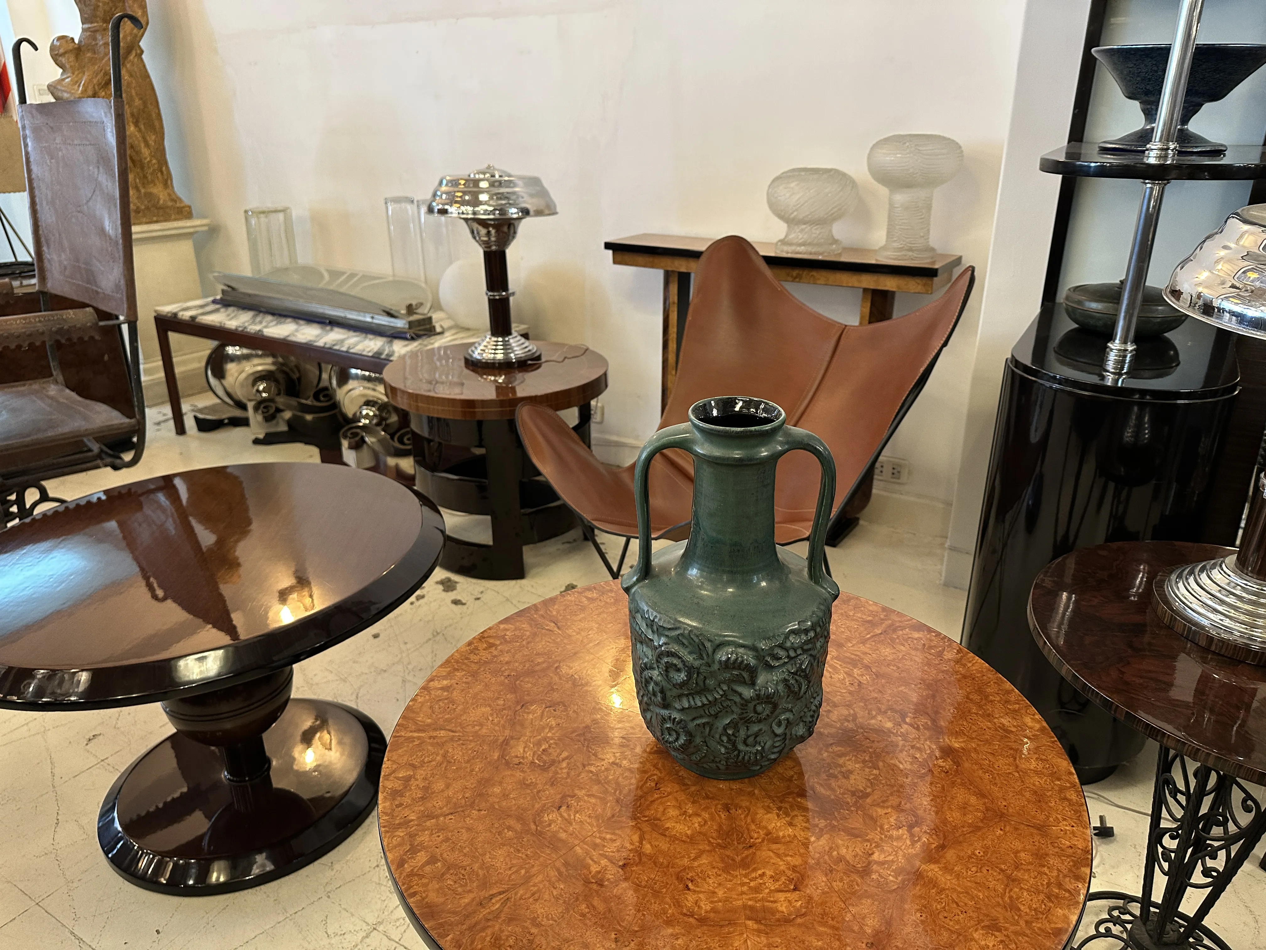 Vaso di ceramica antica in un ambiente decorativo con tavoli di design.