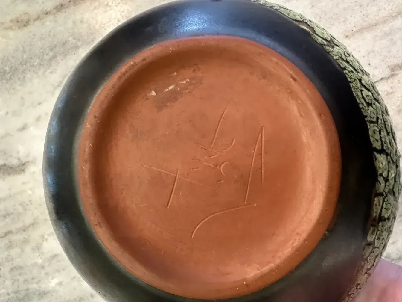 Antica ciotola in ceramica decorata con dettagli testurizzati verdi simili a foglie. Presenta un design elegante e attraente.