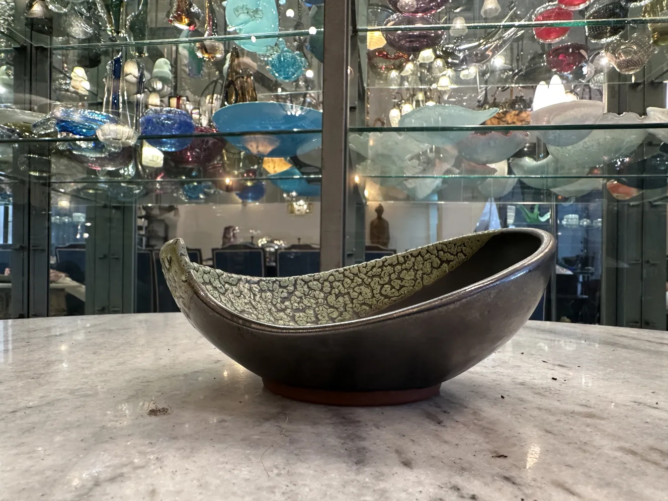 Antique decorated ceramic bowl with green textured details resembling leaves. Displays an elegant and appealing design.