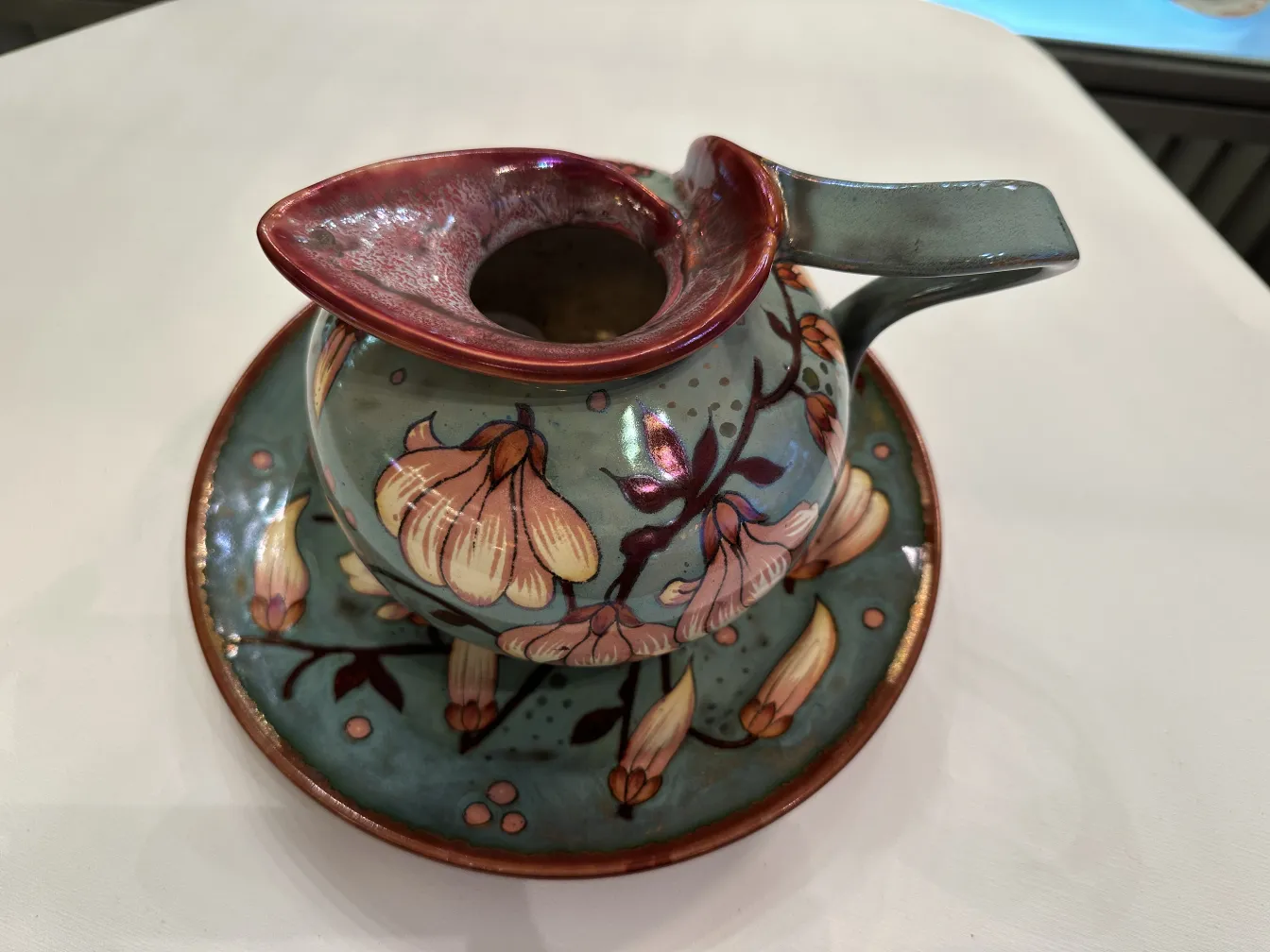 Brocca in ceramica antica con design floreale e piatto