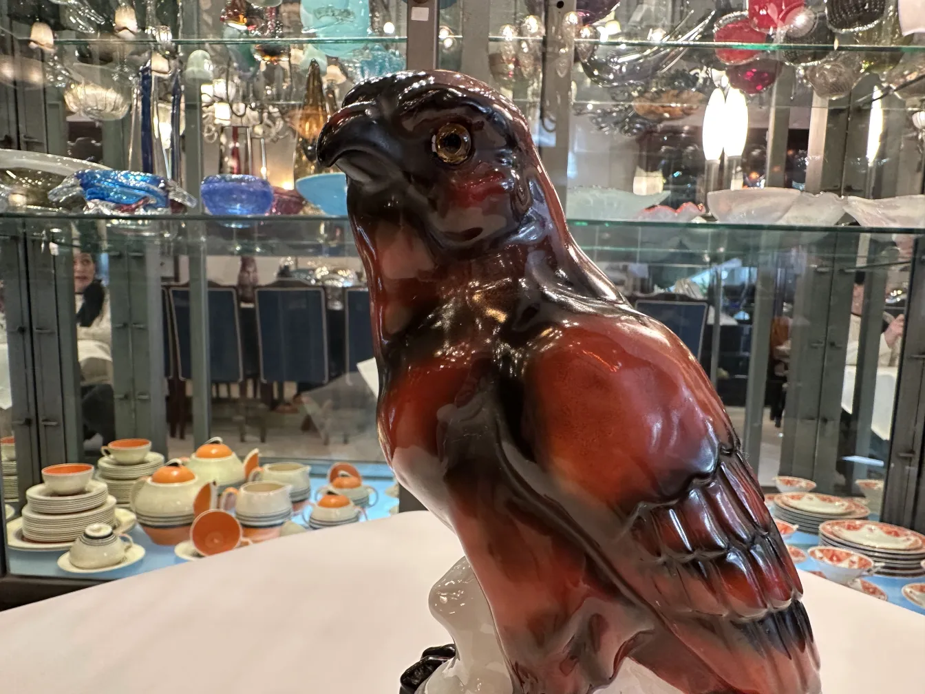 Sculpture ancienne en céramique en forme d'oiseau, exposée dans une vitrine.