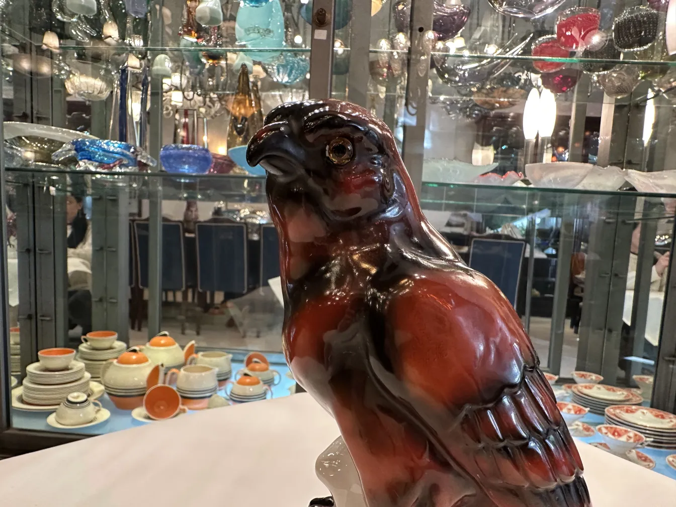 escultura de ceramica antigua con detalles elaborados, un halcón en tonos marrones y negros en un fondo de antigüedades