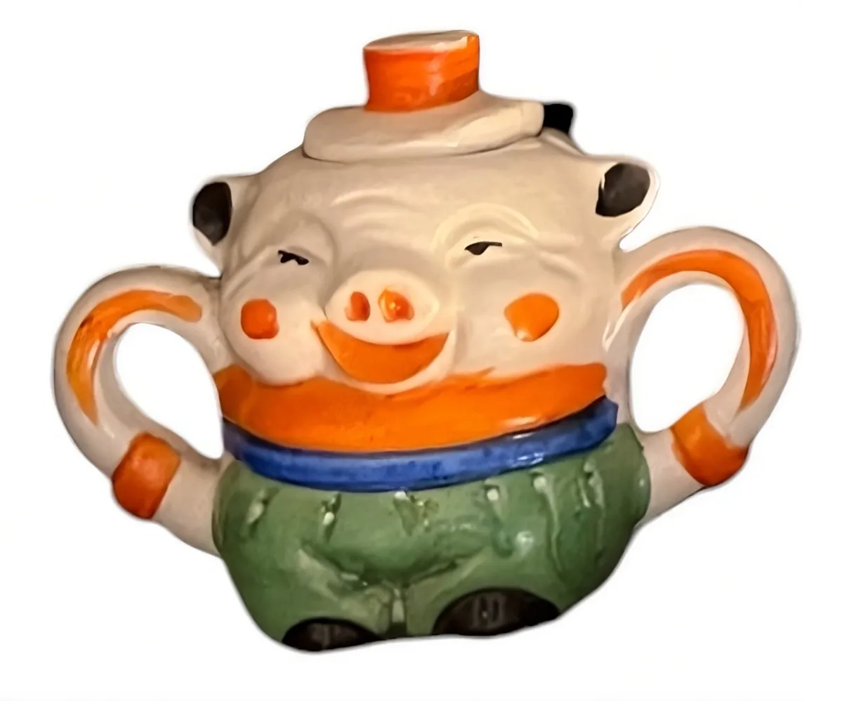 Juego de té antiguo con un diseño juguetón de cerdito y colores brillantes.