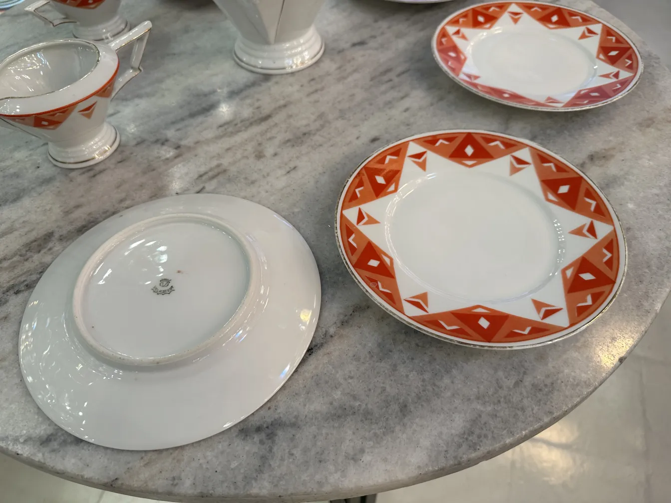 Service à thé ancien Volkstedt avec motifs colorés sur la table.