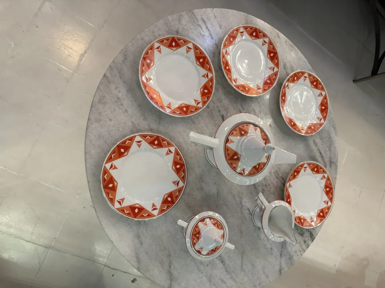 Service à thé ancien Volkstedt avec motifs colorés sur la table.