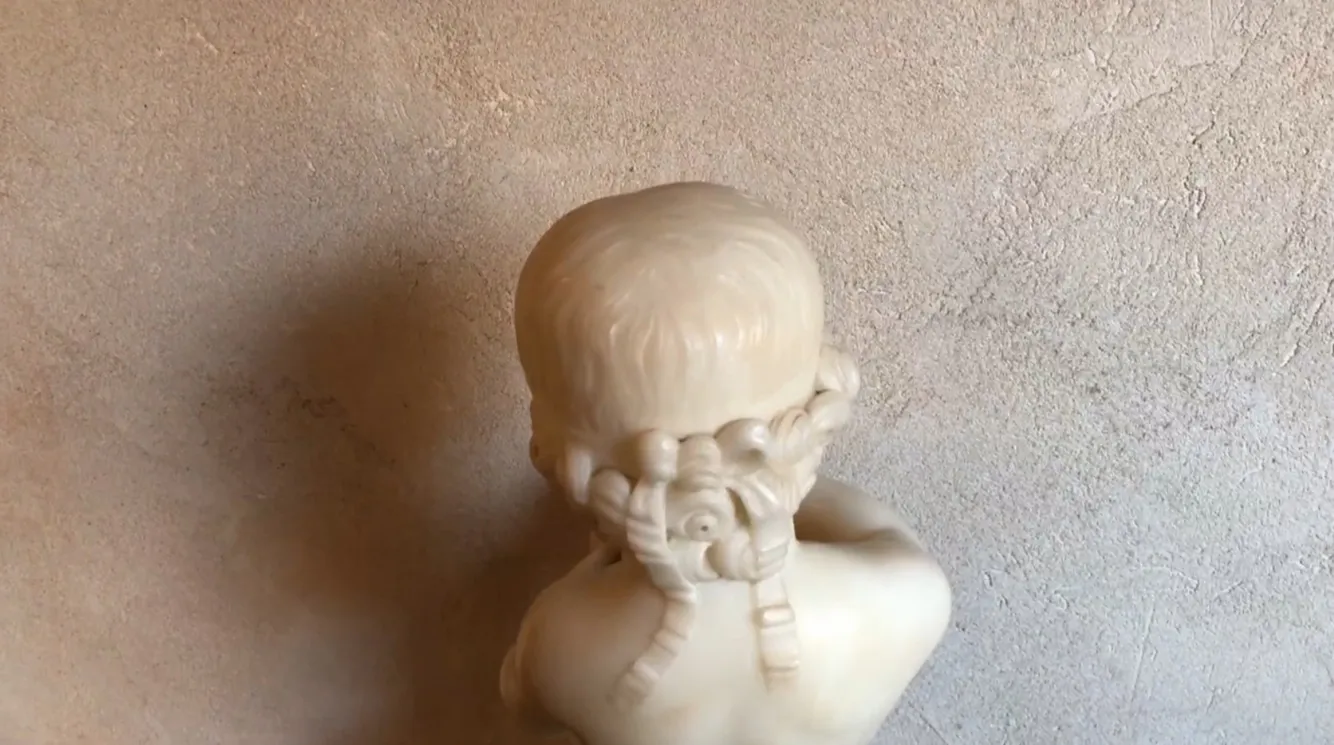 antique sculpture of a child holding a bird