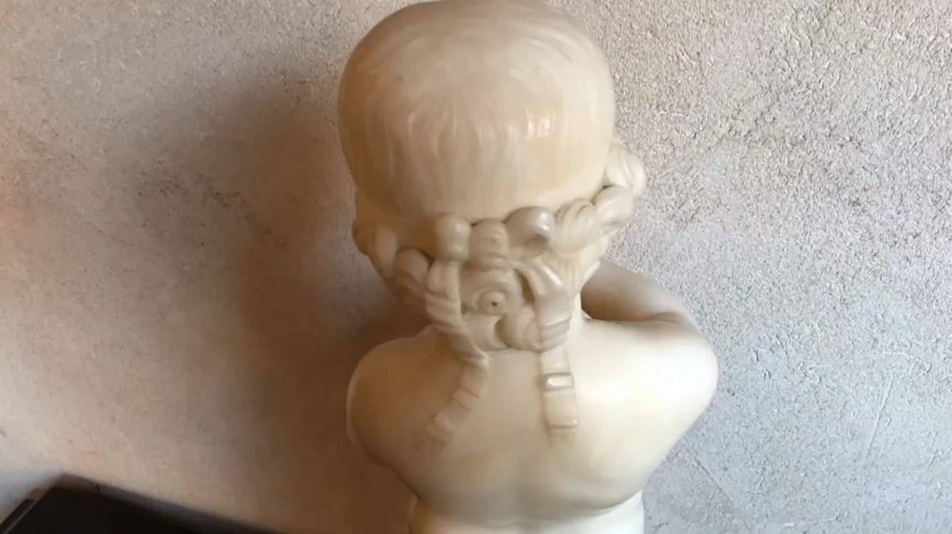 escultura antiga de uma criança segurando um pássaro