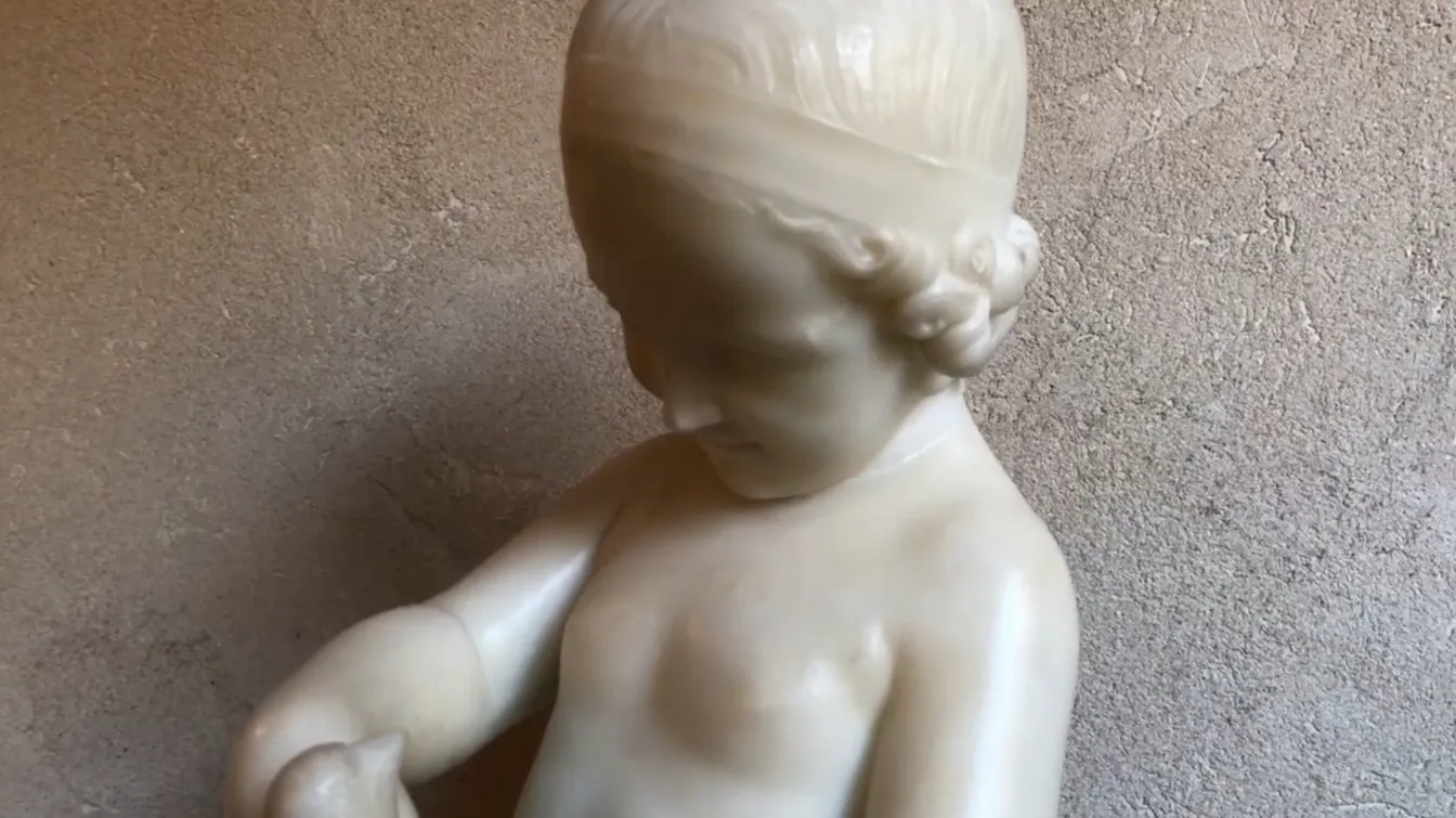 escultura antiga de uma criança segurando um pássaro