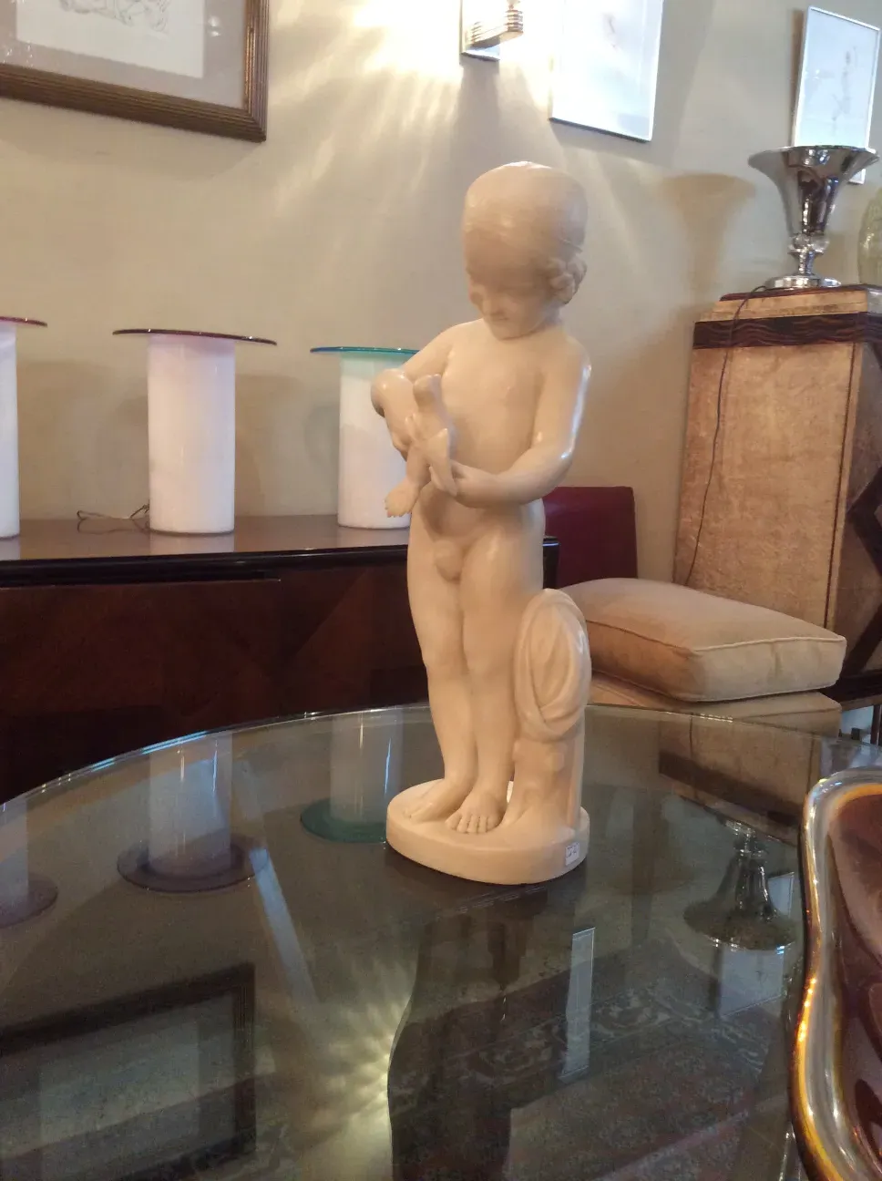 scultura antica di un bambino che tiene un uccello
