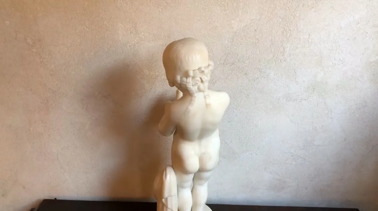 escultura antiga de uma criança segurando um pássaro