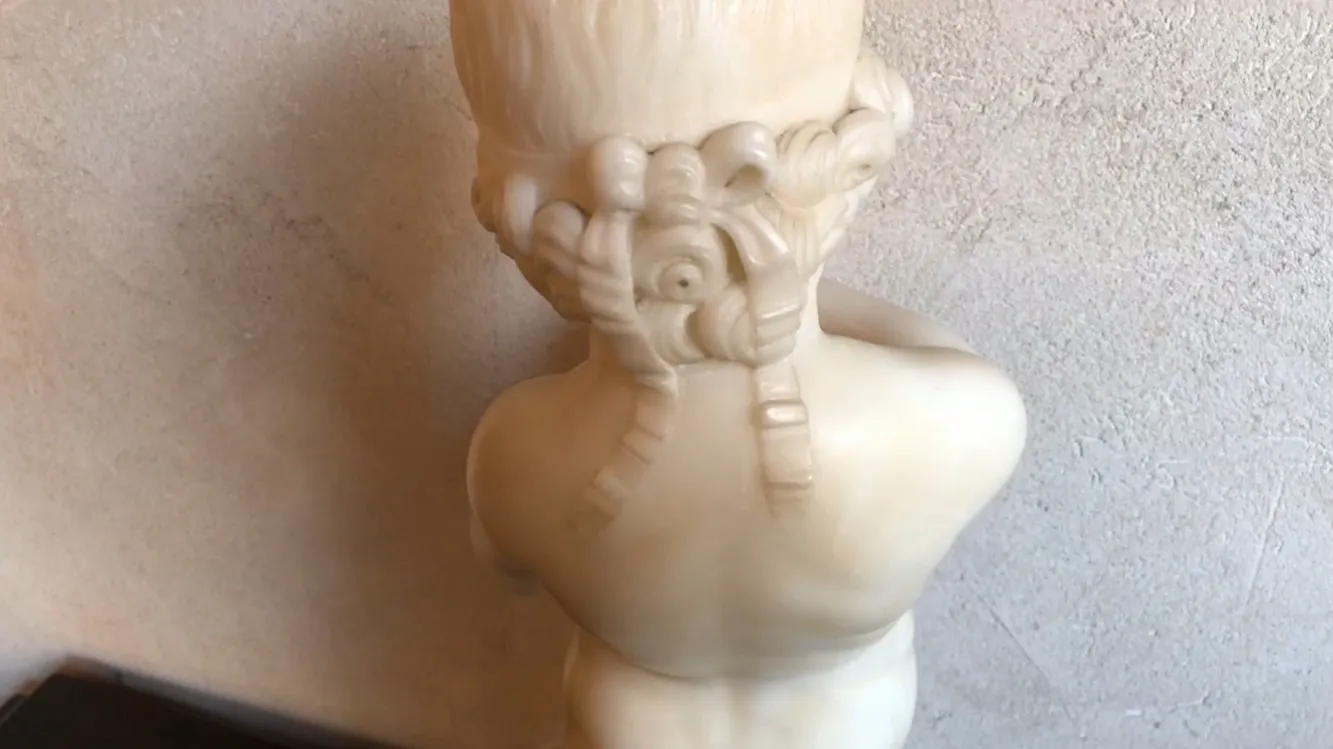 escultura antigua de un niño sosteniendo un pájaro