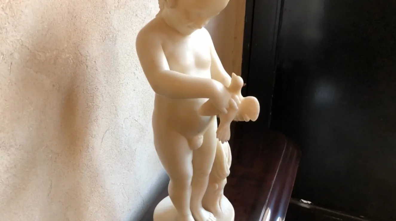 escultura antiga de uma criança segurando um pássaro