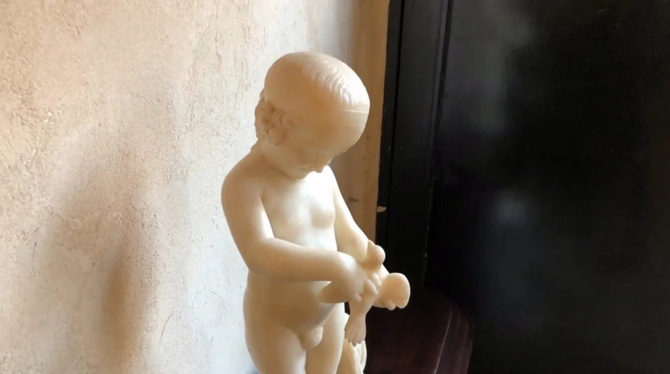 escultura antiga de uma criança segurando um pássaro