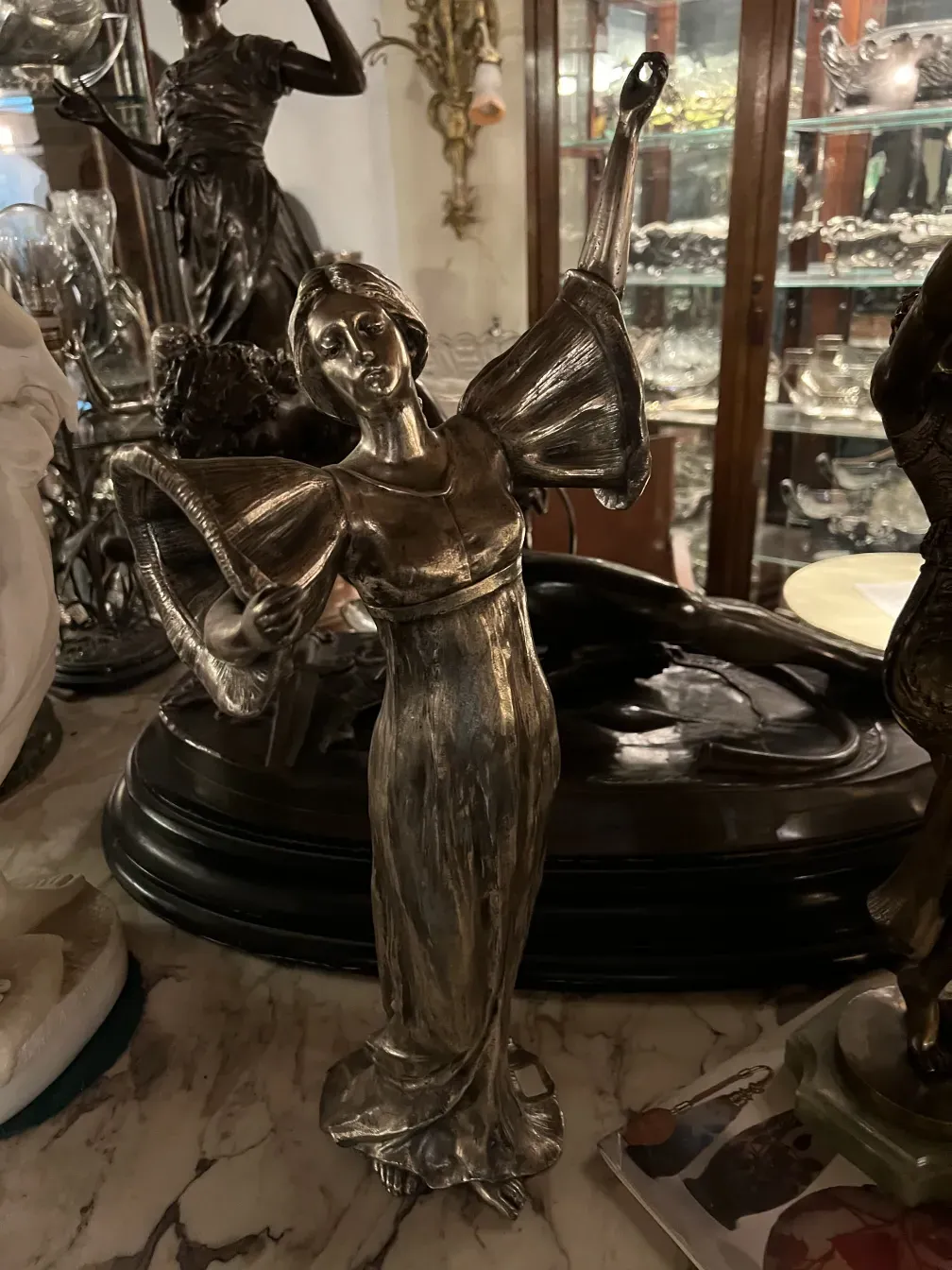escultura antiga de mulher dançando com os braços levantados