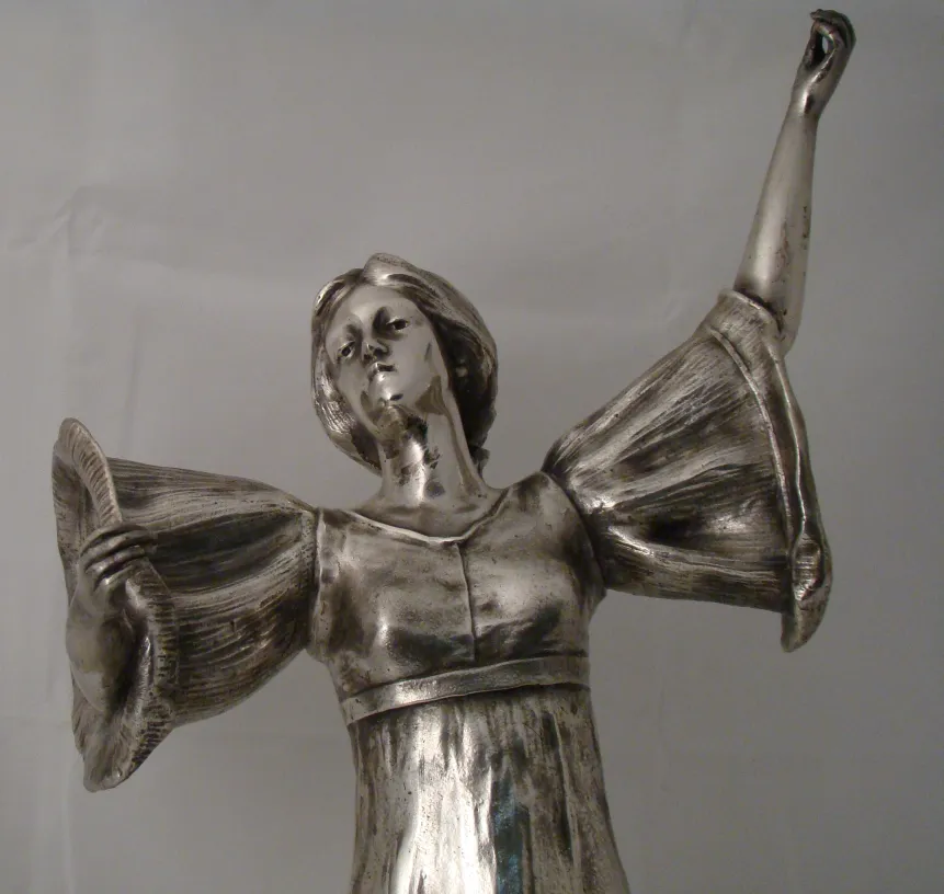 escultura antiga de figura feminina com braços levantados