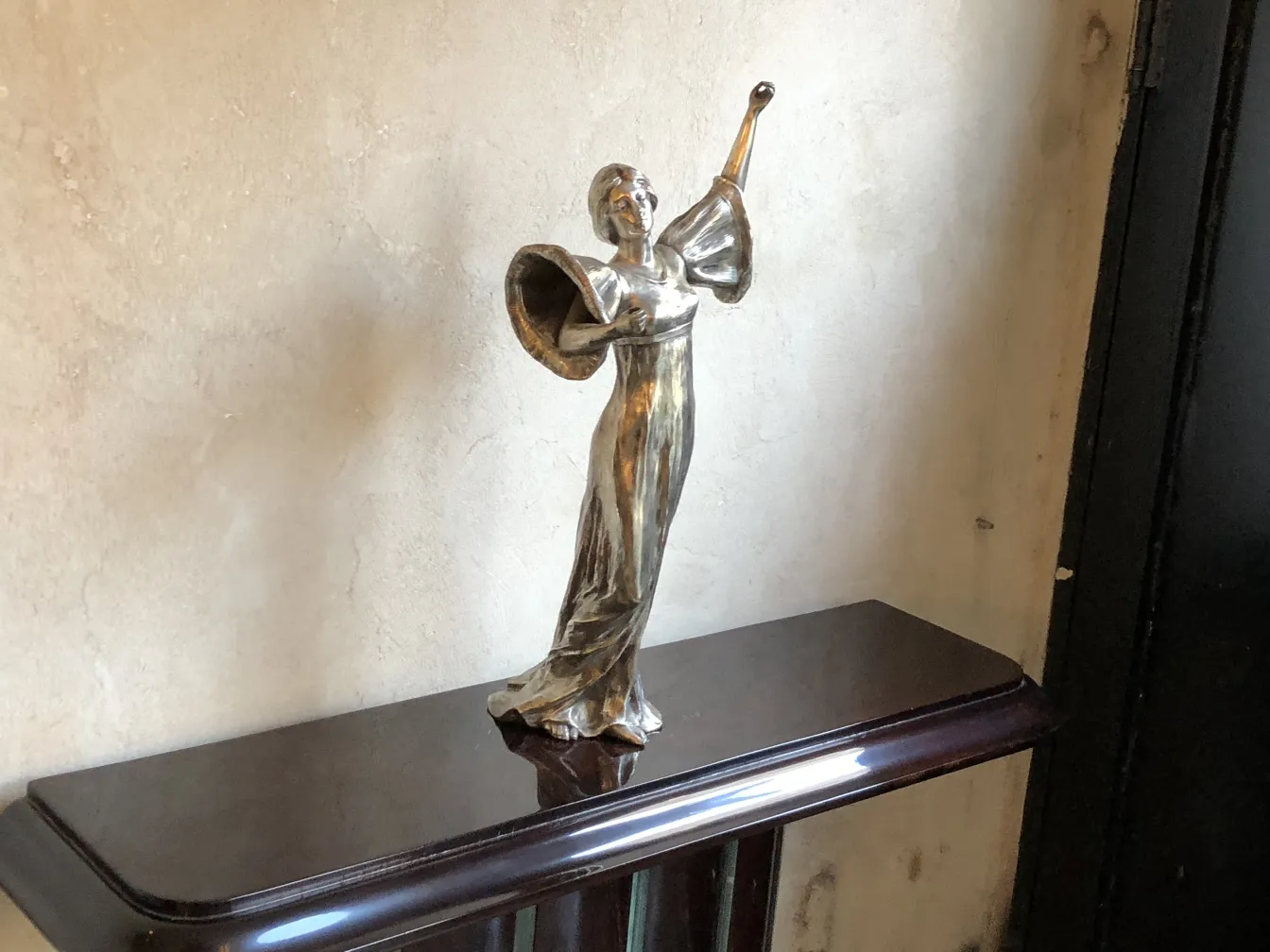 Escultura antiga de figura dançante em um pedestal elegante