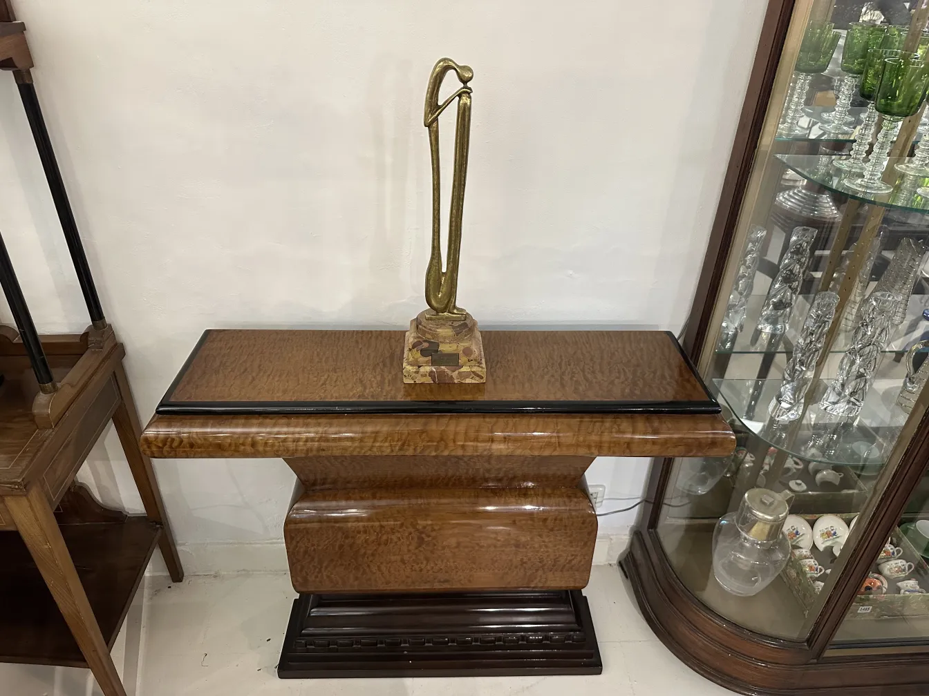 Escultura antiga com forma elegante e base decorativa.