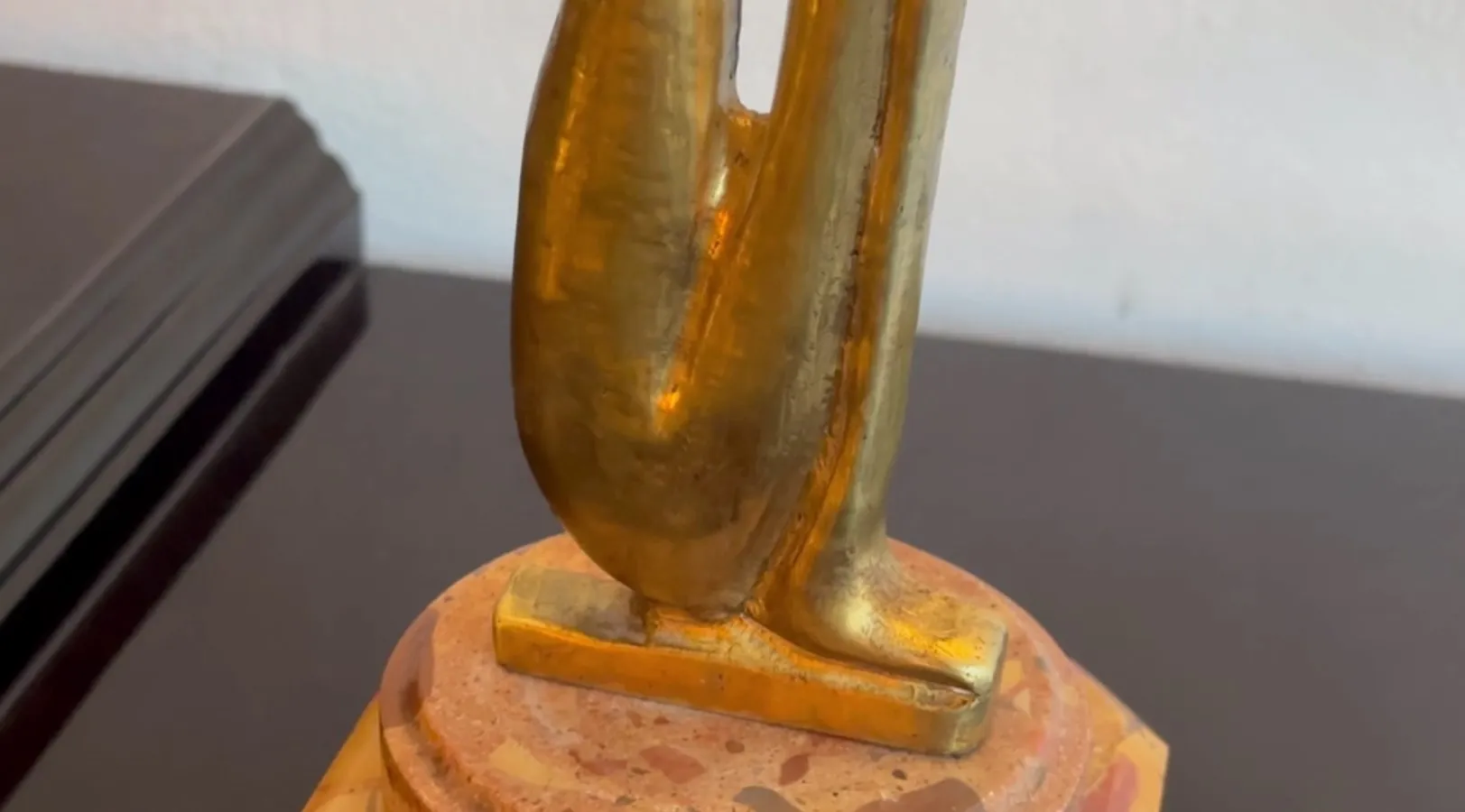 Escultura antiga com forma elegante e base decorativa.