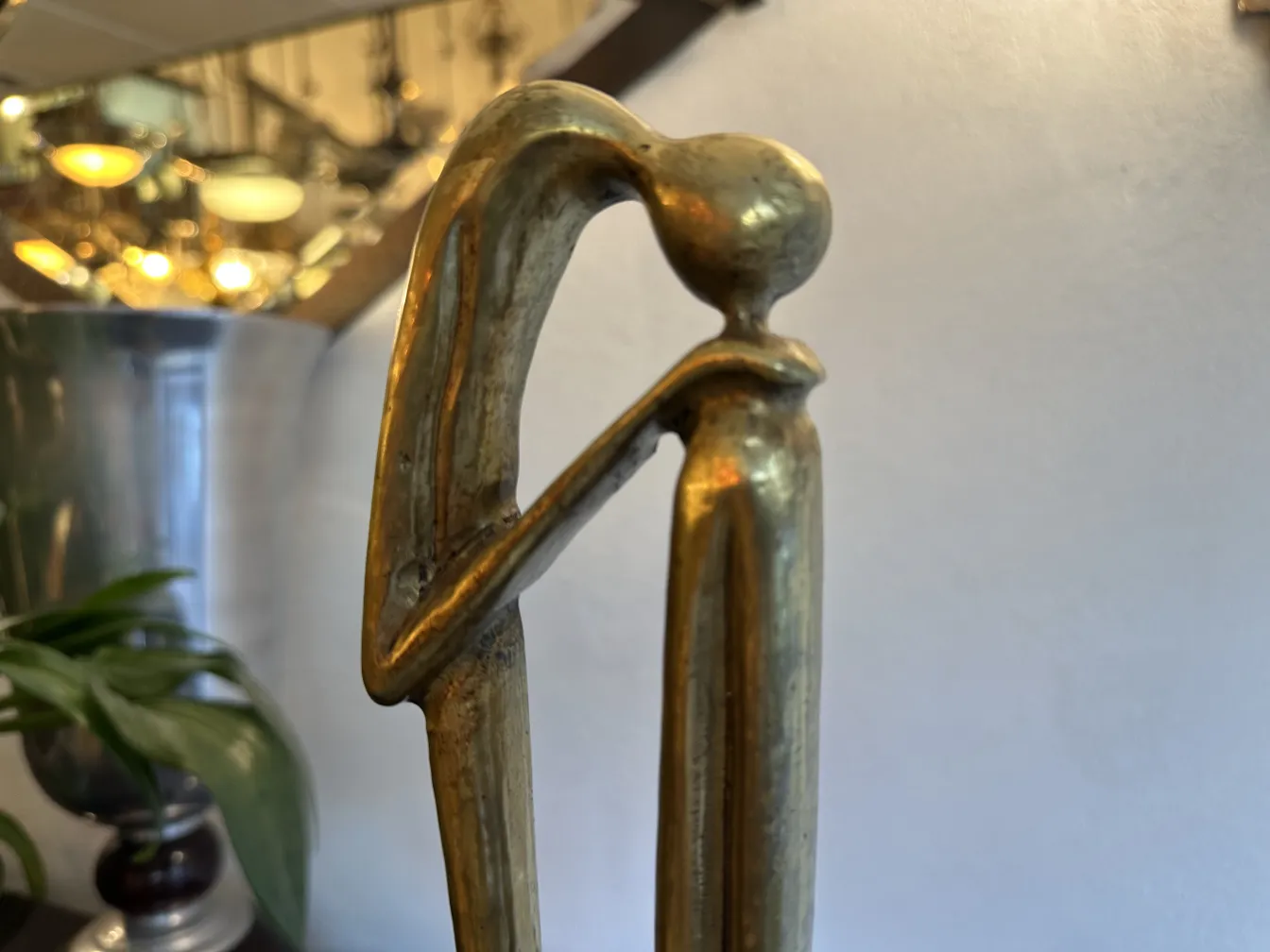 Escultura antigua con forma estilizada y base decorativa.