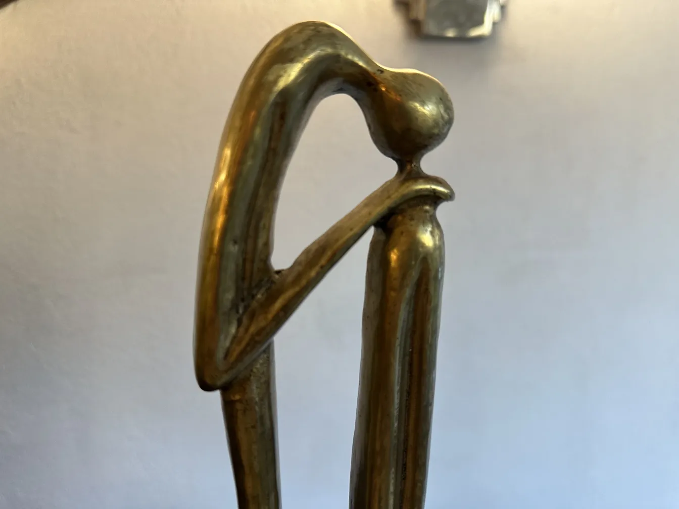 Escultura antiga com forma elegante e base decorativa.
