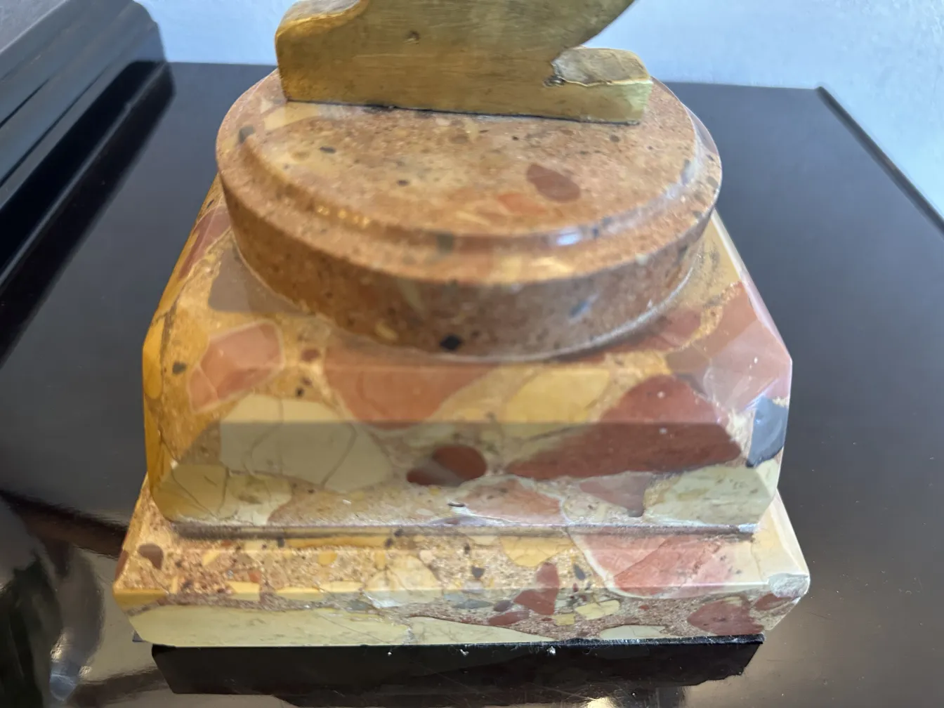 Escultura antiga com forma elegante e base decorativa.