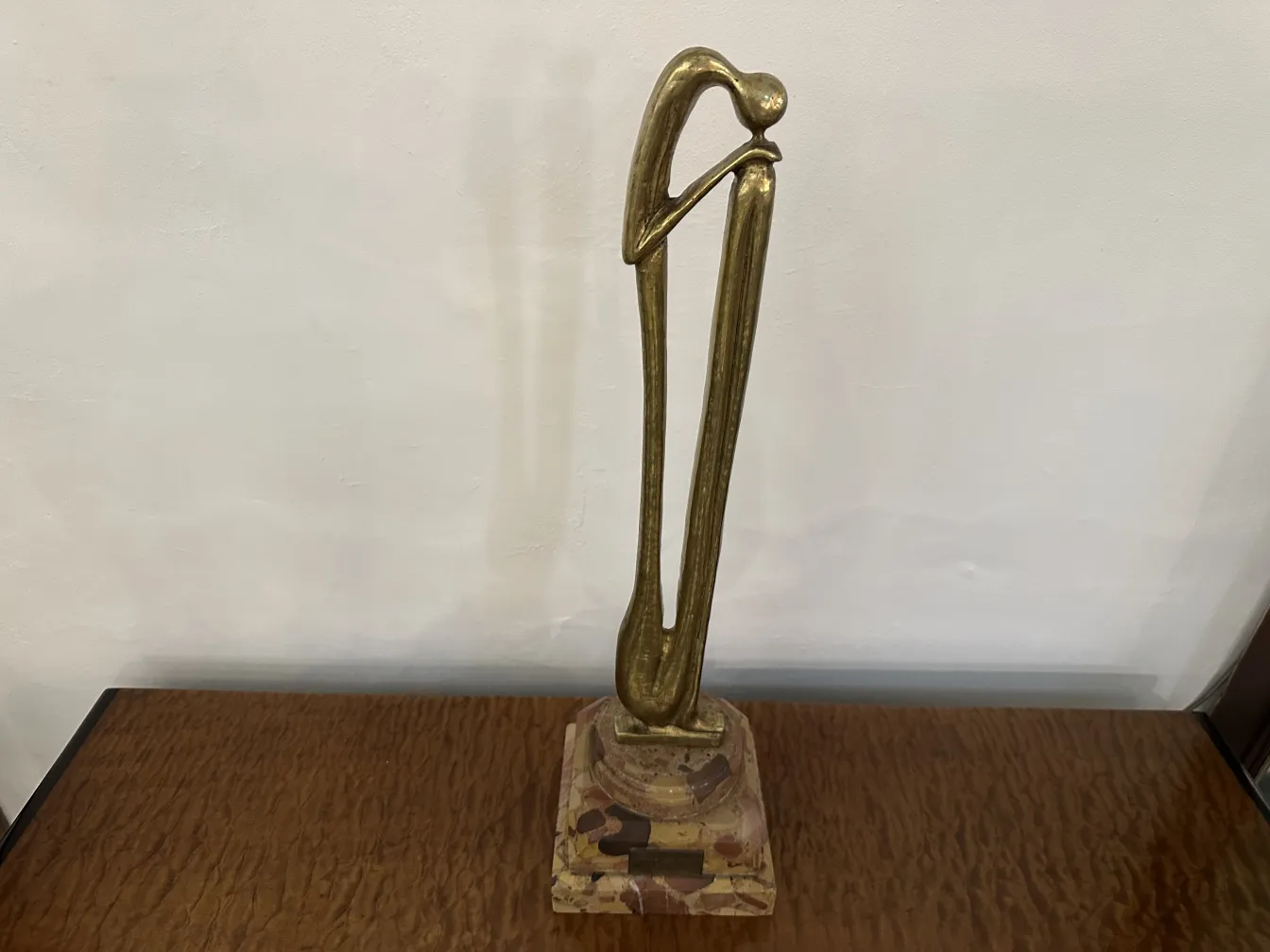 Escultura antiga com forma elegante e base decorativa.
