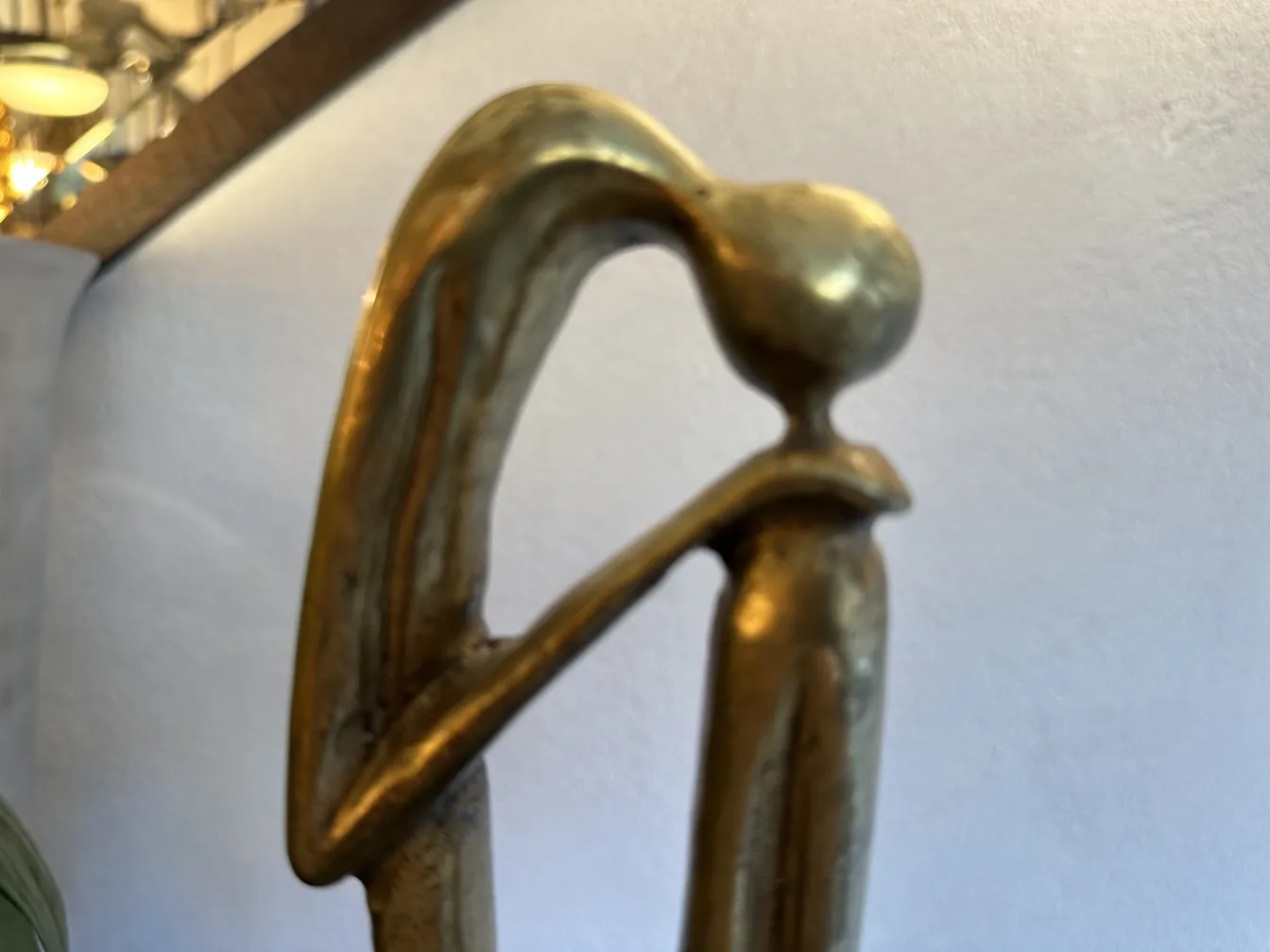 Escultura antigua con forma estilizada y base decorativa.